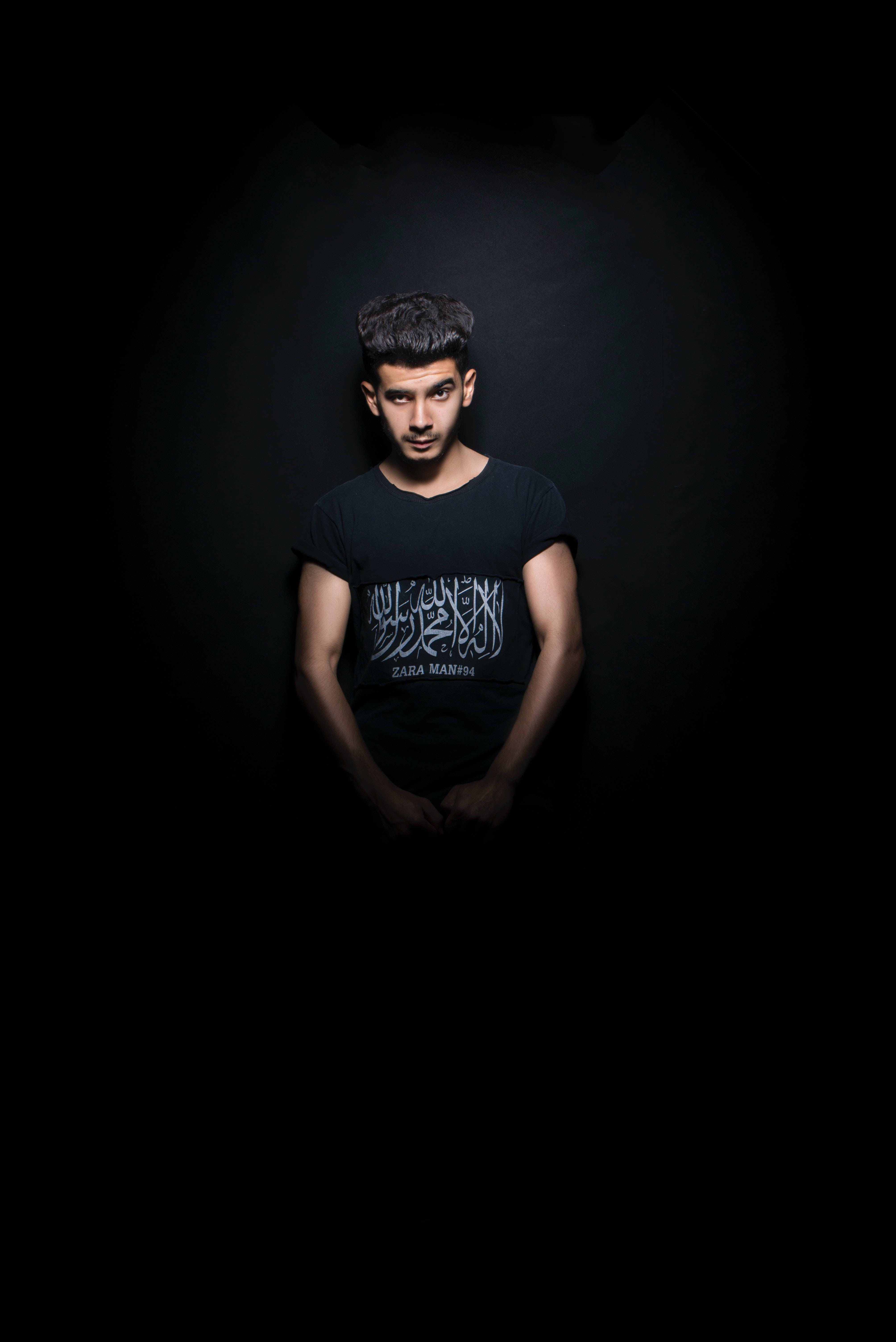 black t-shirt, dramatic spotlight, pitch-black background, 5K Phone Wallpaper