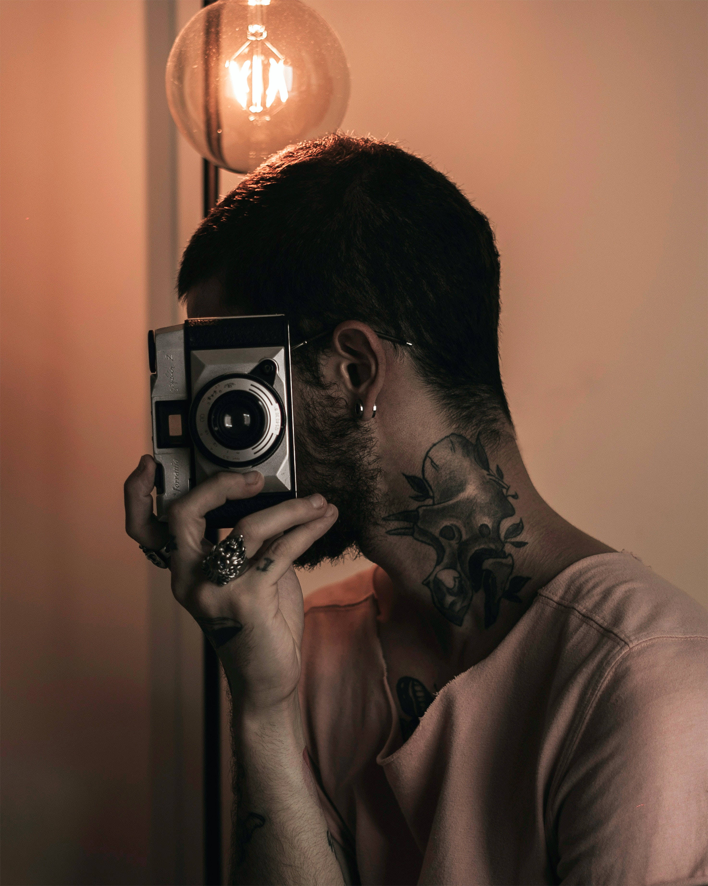 vintage camera, warm glowing bulb, softly lit room, 2K Phone Wallpaper