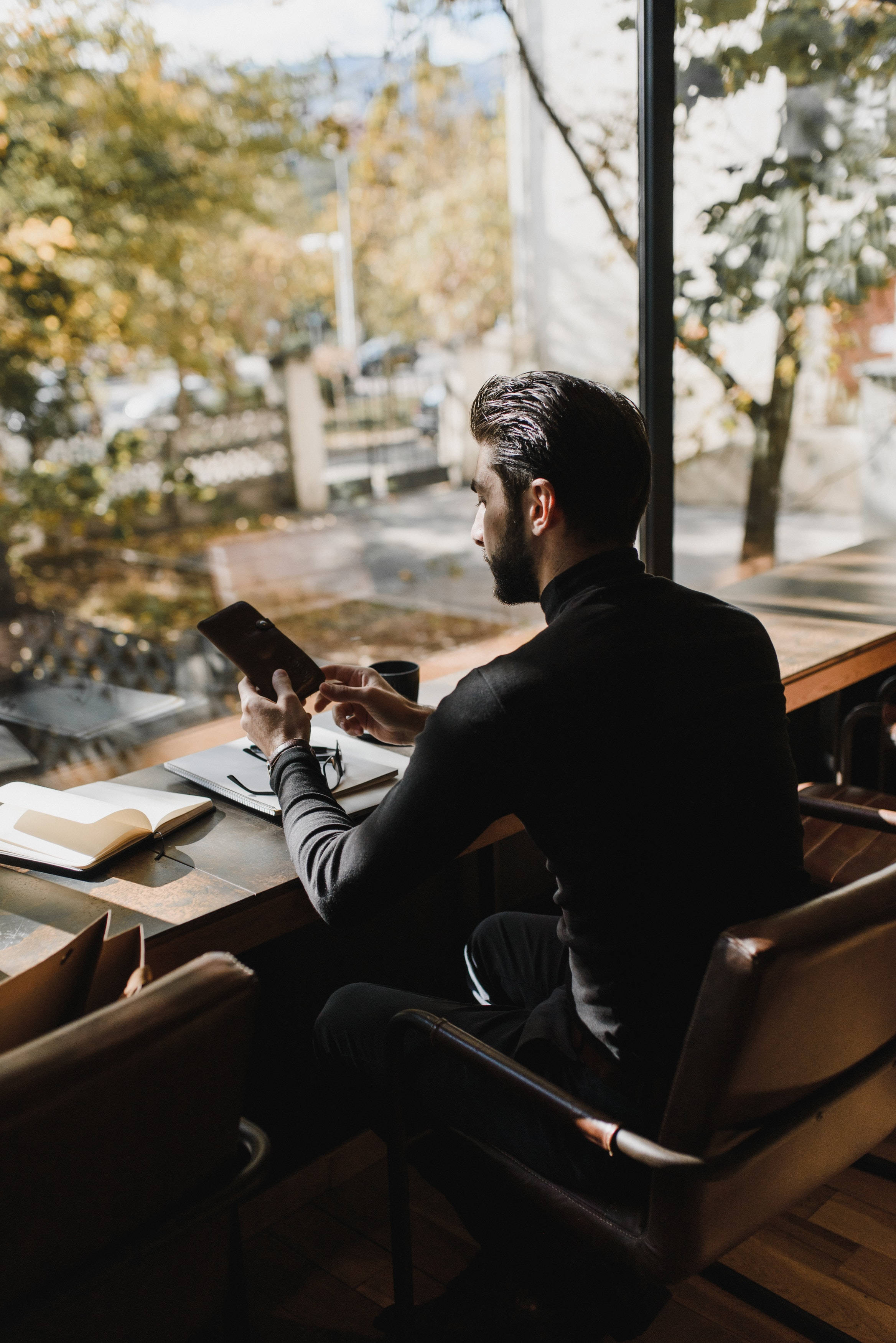 black turtleneck, wooden table, large window, 2K Phone Wallpaper