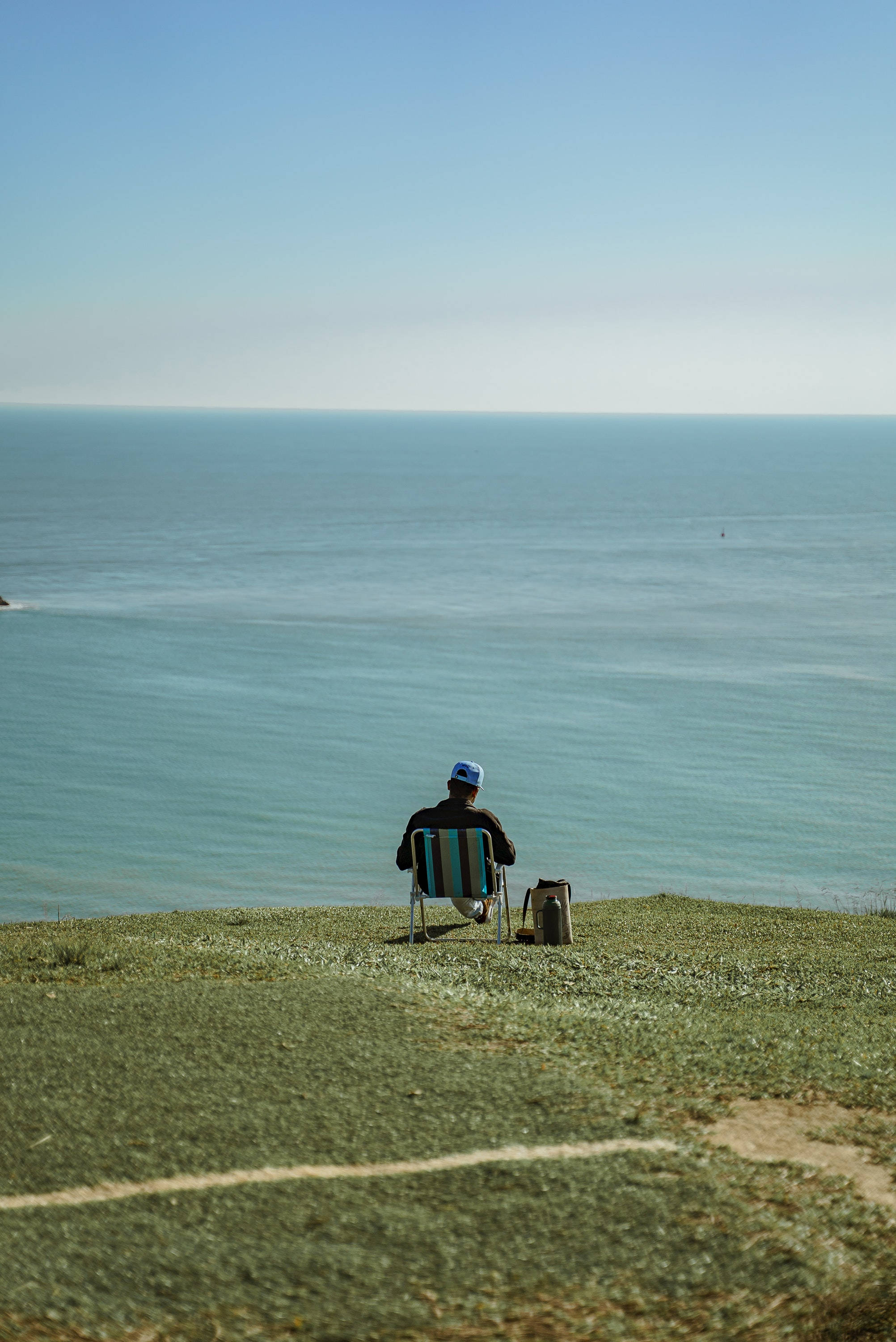 Man Aesthetic, striped chair, grassy cliff, 2K Phone Wallpaper