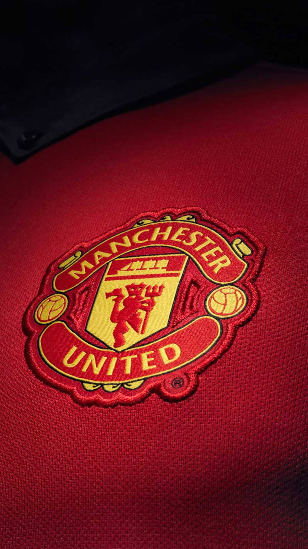 Manchester United crest, red football jersey, dramatic lighting, Full HD Phone Wallpaper