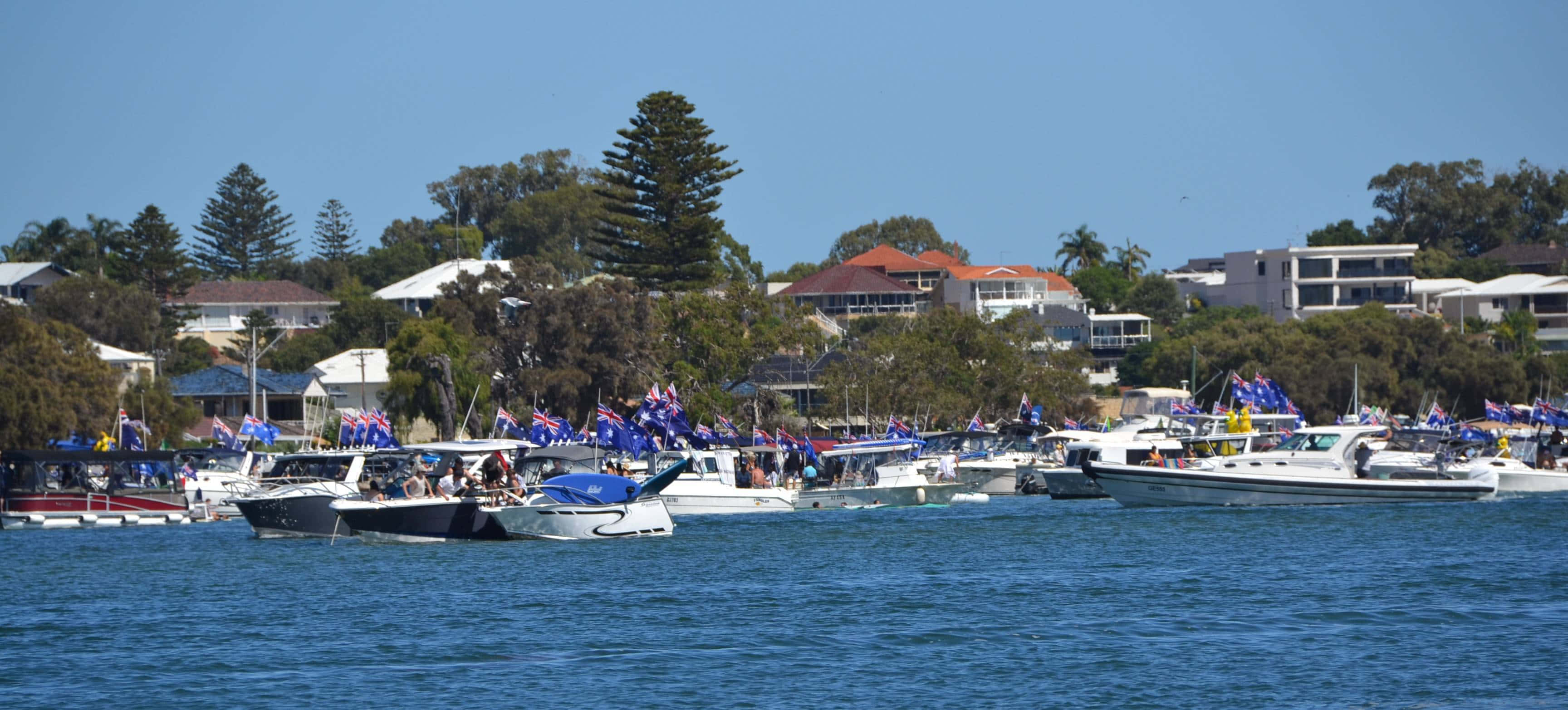 Mandurah, blue and gold flags, calm blue water, 2K Desktop Wallpaper