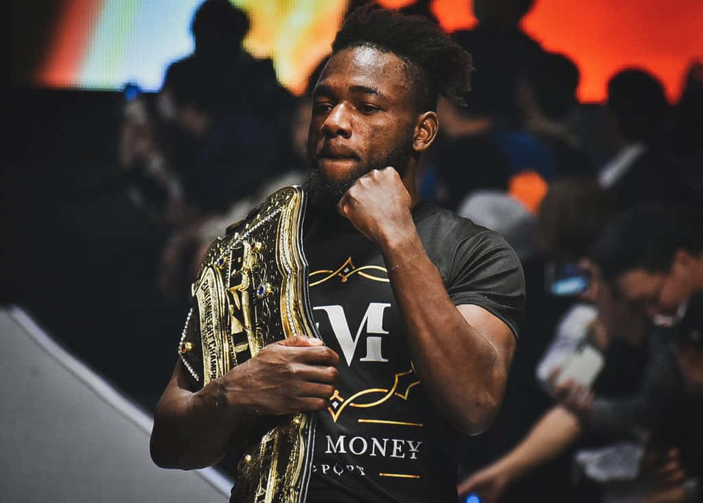 Manel Kape, black 'Money' shirt, gleaming gold championship belt, SD Desktop Wallpaper