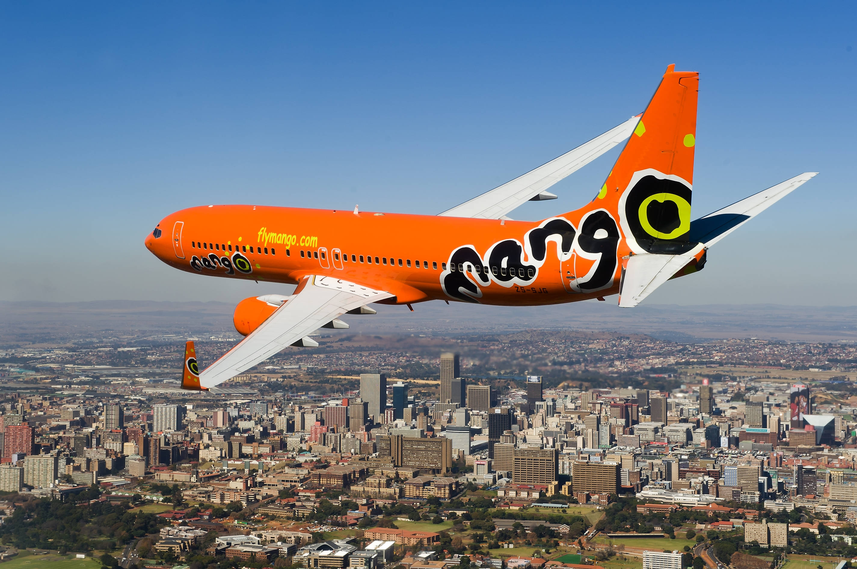 Mango Airlines, orange airplane, urban landscape, 2K Desktop Wallpaper