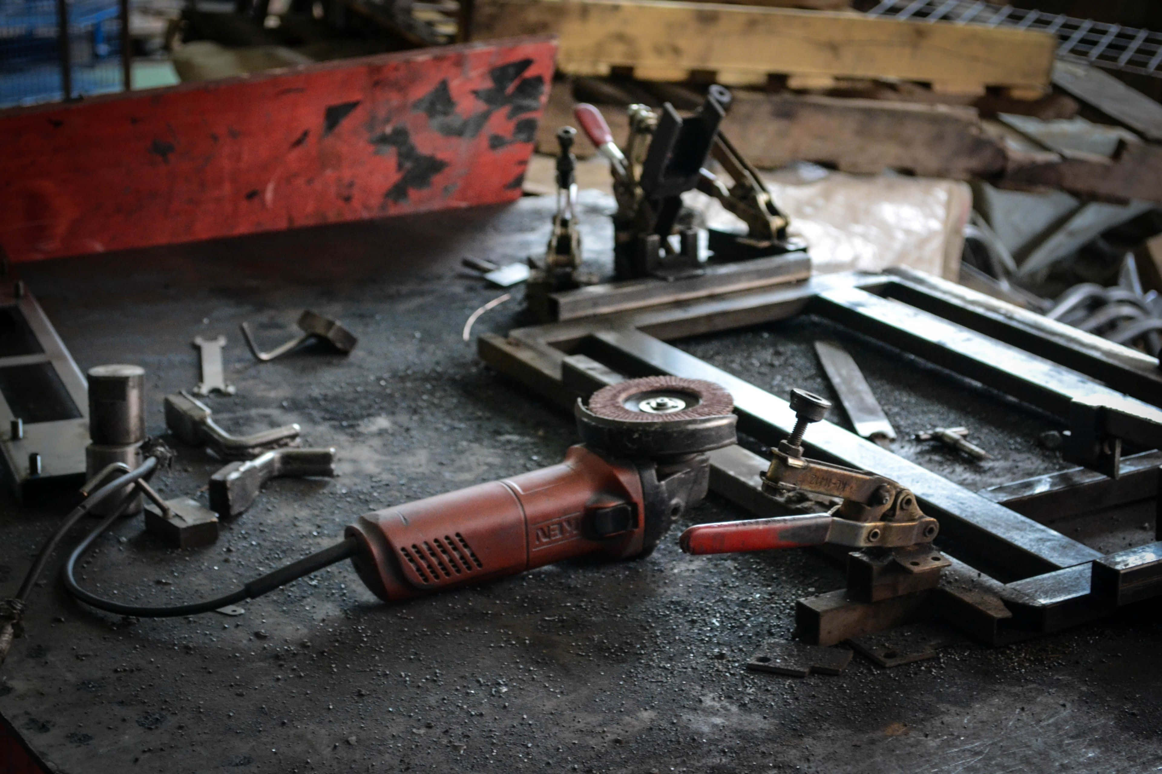 red angle grinder, gritty metal workbench, scattered tools, 4K Desktop Wallpaper