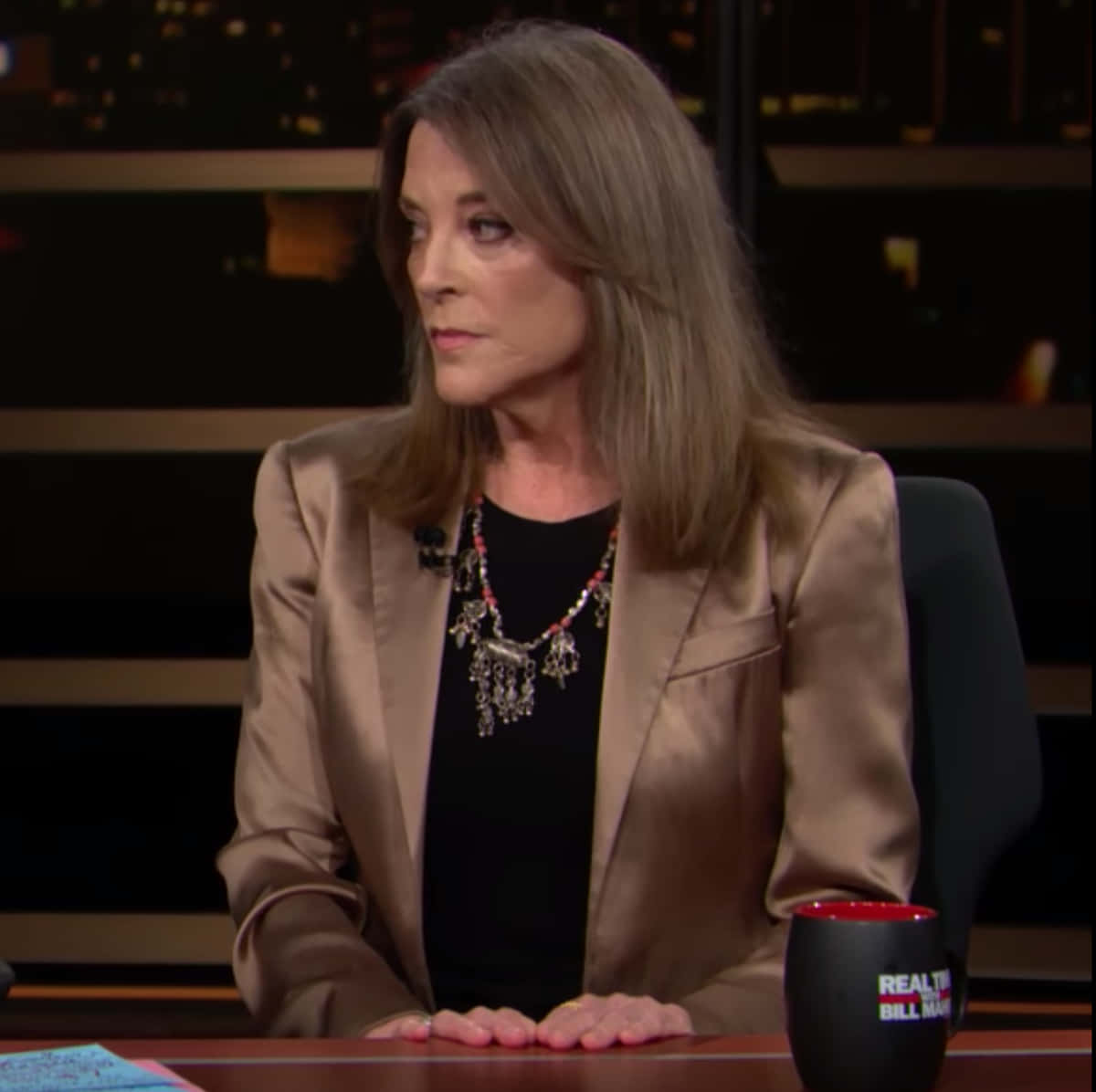Marianne Williamson, gold blazer, mug labeled 'Real Time with Bill Maher', SD Desktop Wallpaper