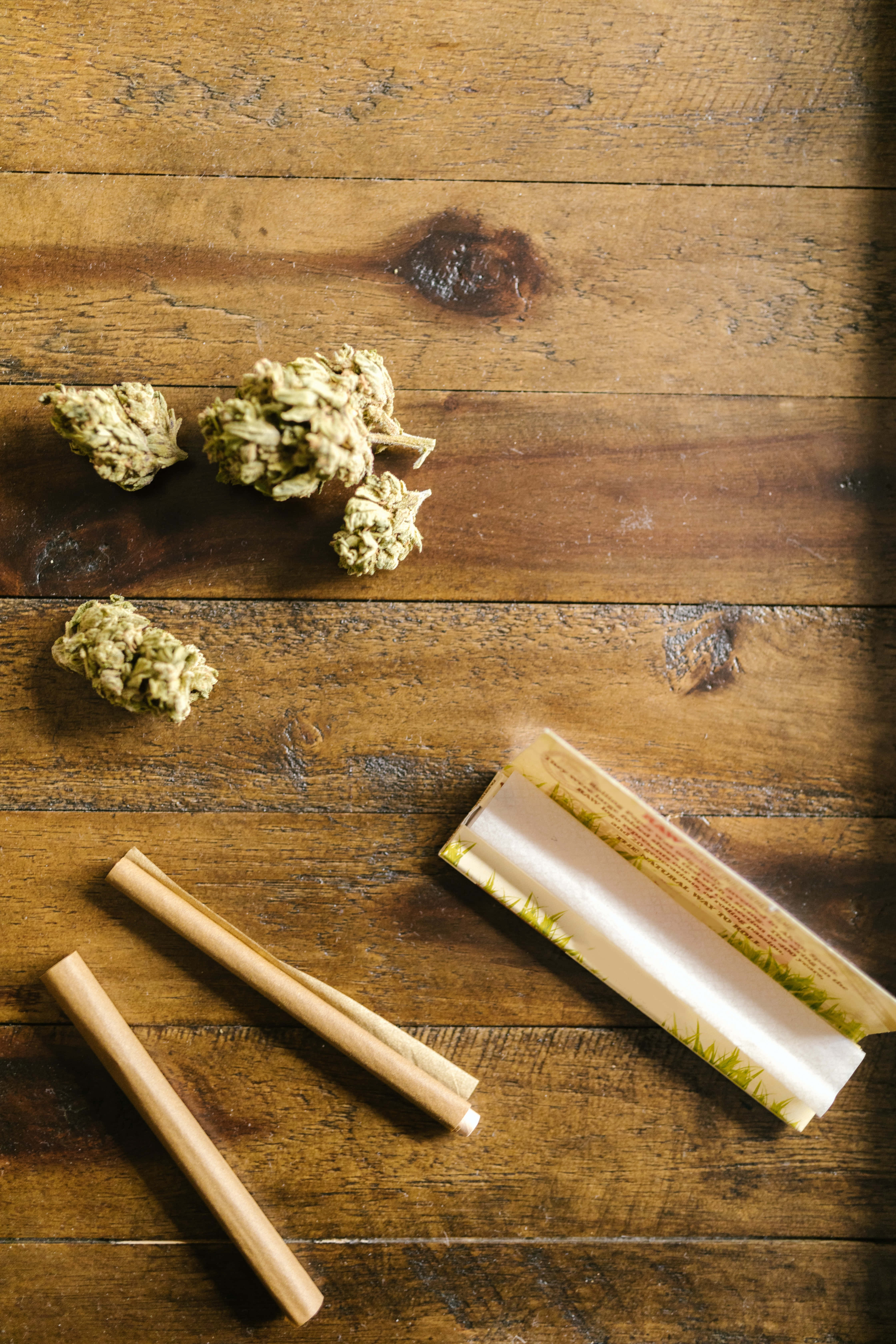 cannabis buds, rolling papers, weathered wooden surface, 5K Phone Wallpaper
