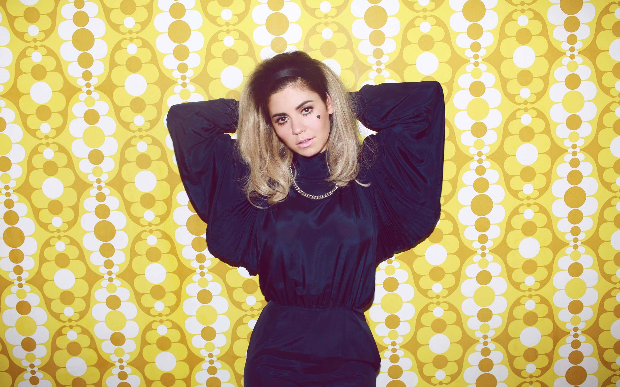 Marina and the diamonds, dark blue dress, bold yellow and white retro patterned wallpaper, 2K Desktop Wallpaper