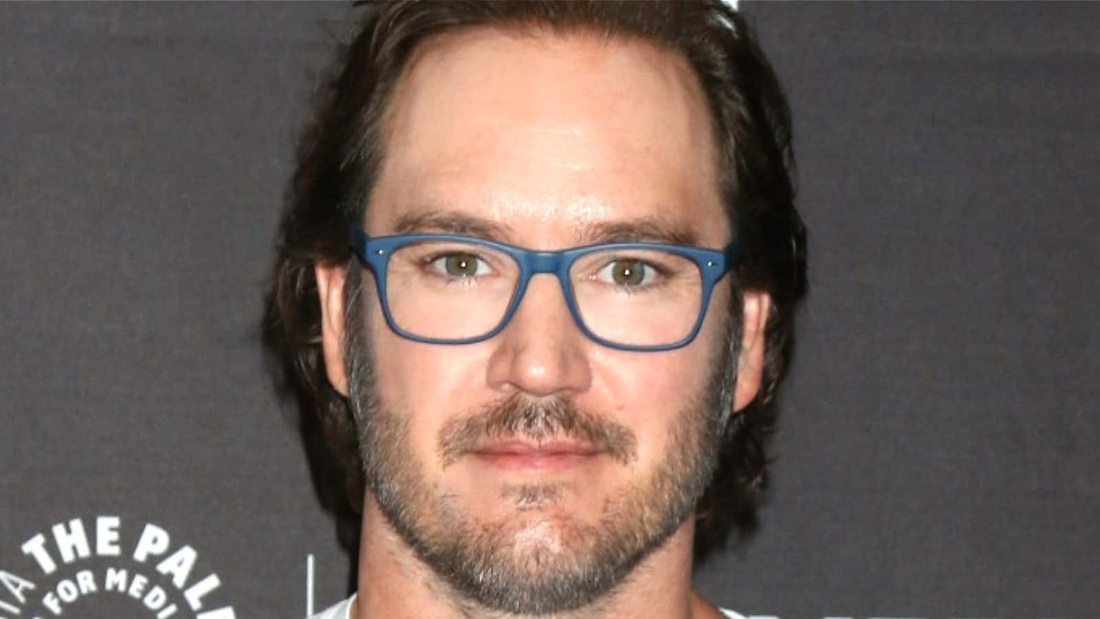 Mark-paul Gosselaar, blue-framed glasses, dark gray backdrop, HD Desktop Wallpaper