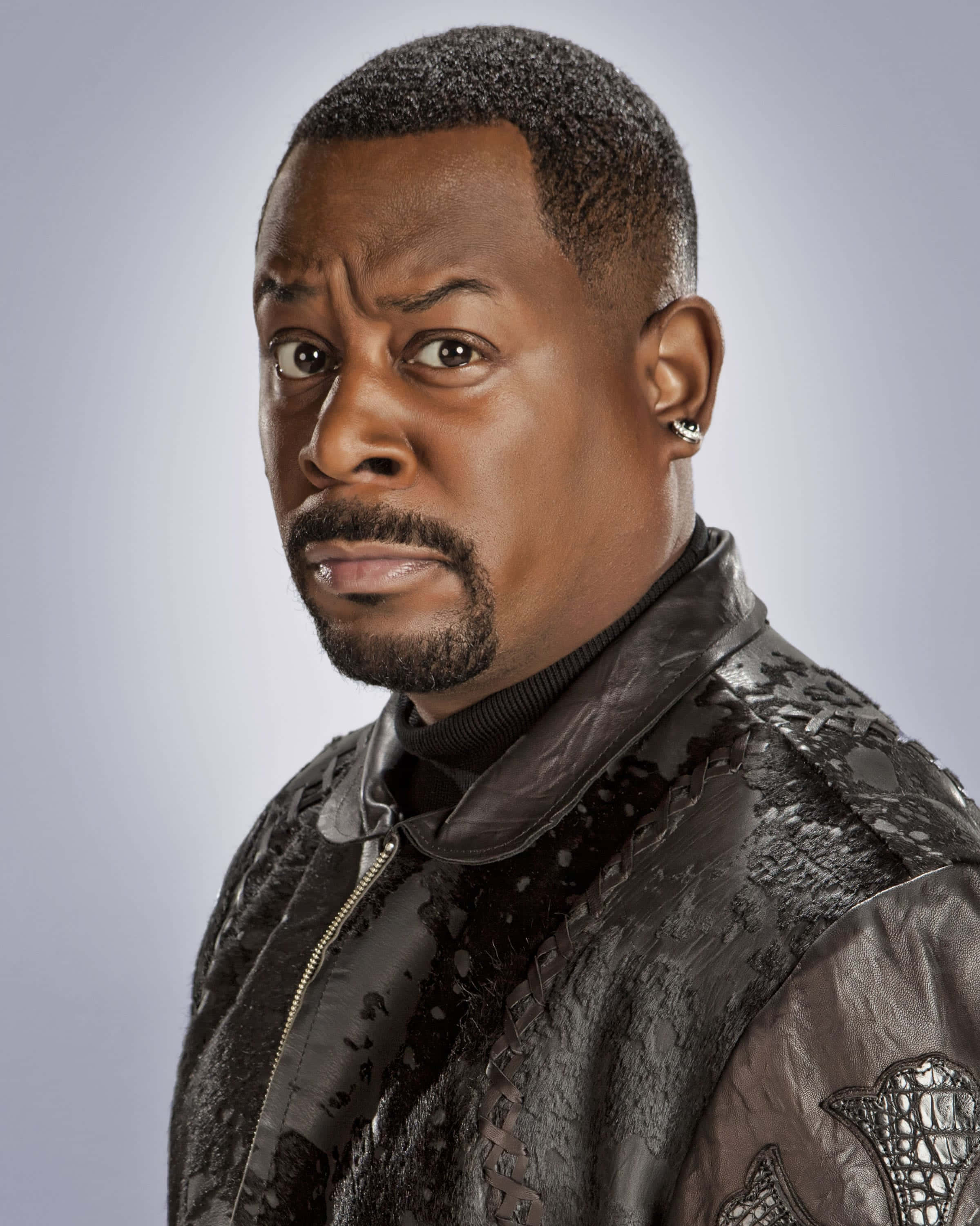 Martin Lawrence, textured black leather jacket, soft gray background, 2K Phone Wallpaper