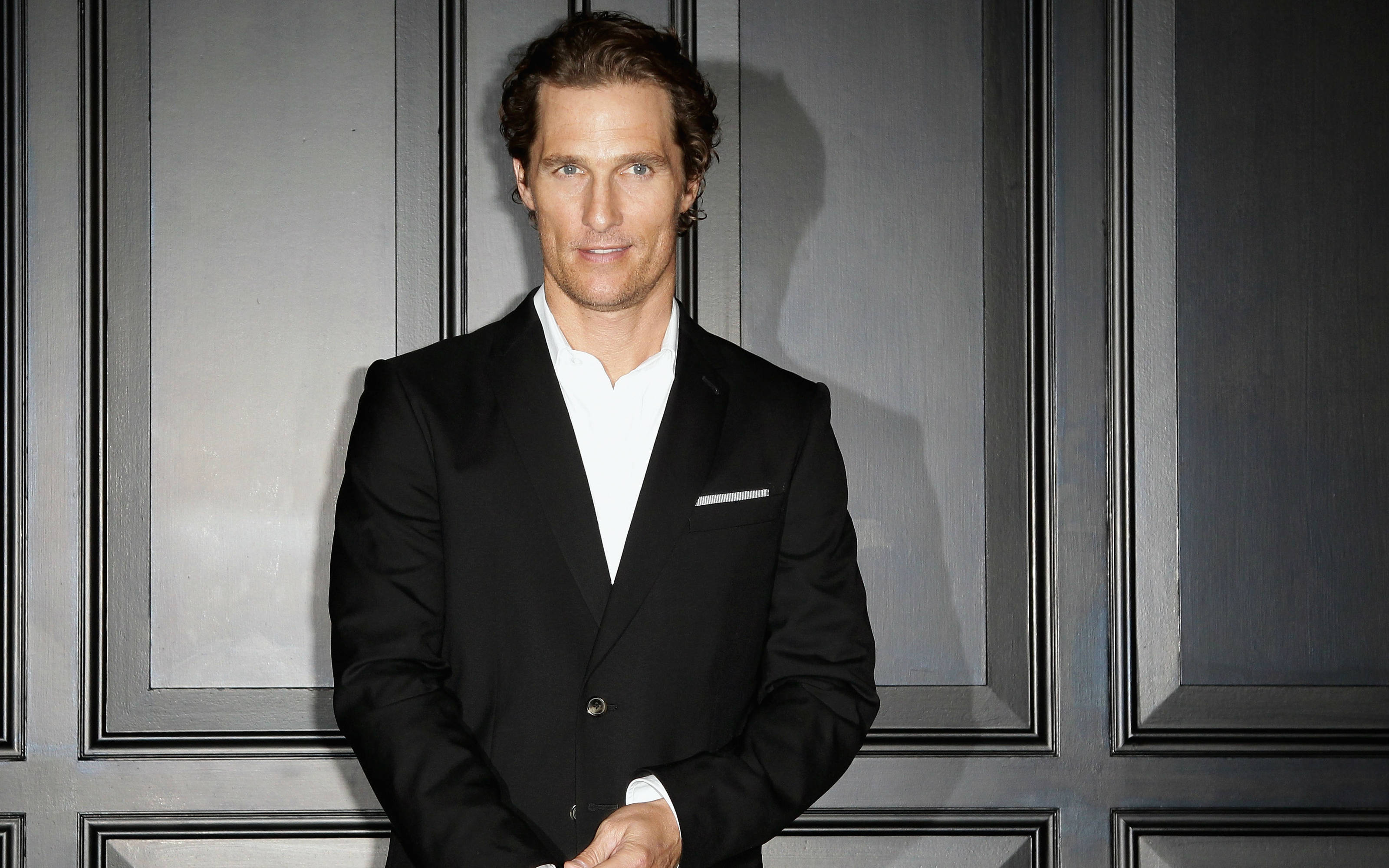Matthew Mcconaughey, black suit, sleek gray paneled wall, 2K Desktop Wallpaper