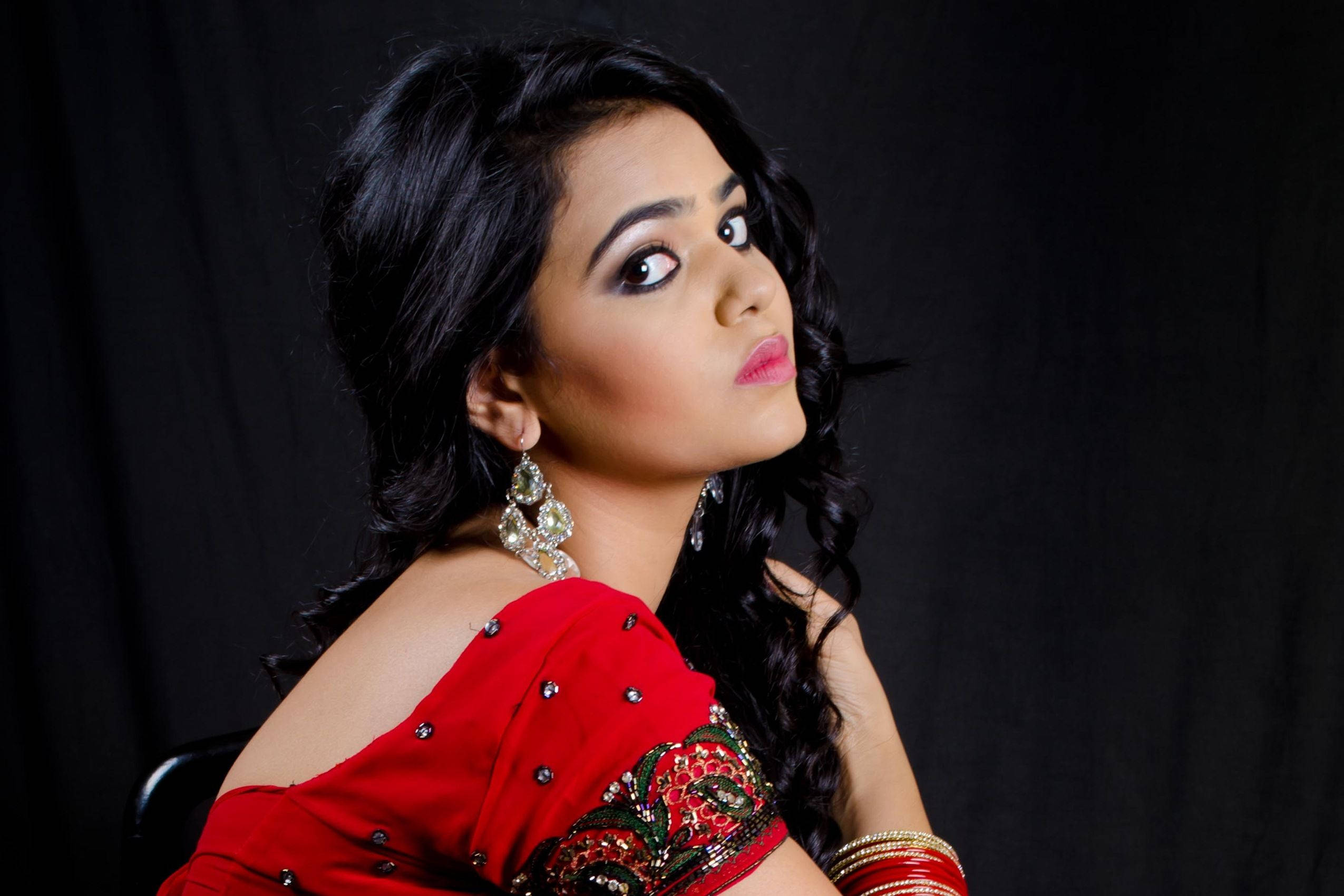 vibrant red traditional outfit, playful expression, black backdrop, Full HD Desktop Wallpaper