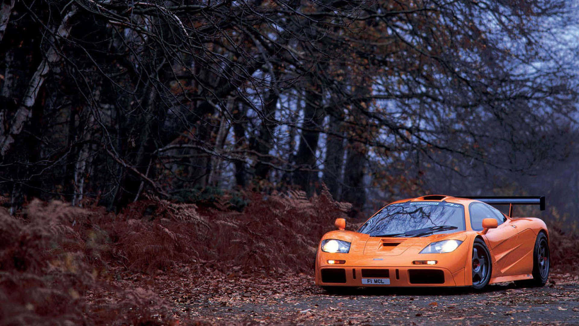 McLaren F1, vibrant orange, forest path, Full HD Desktop Wallpaper