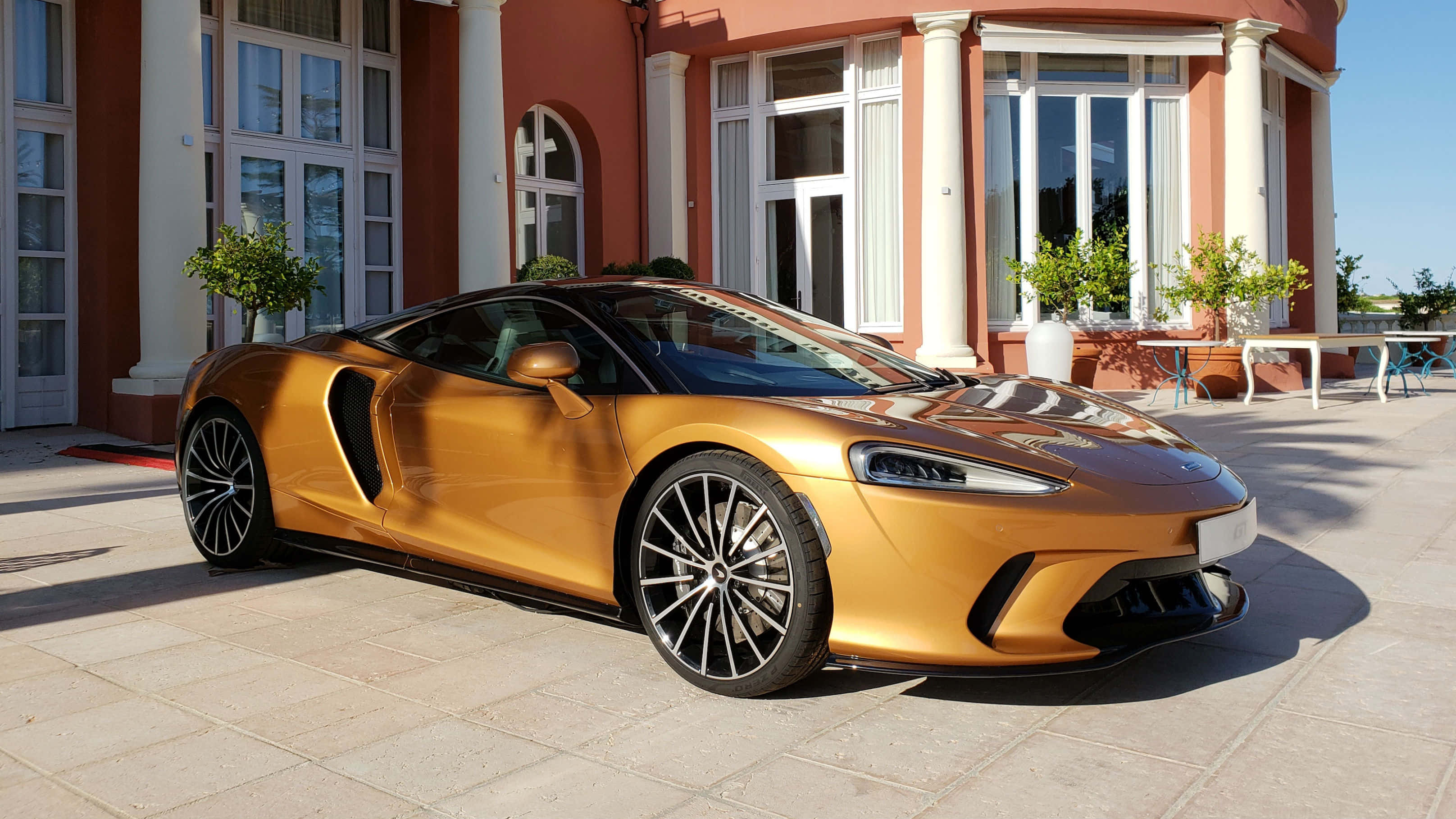 McLaren GT, gold, tiled patio, 2K Desktop Wallpaper