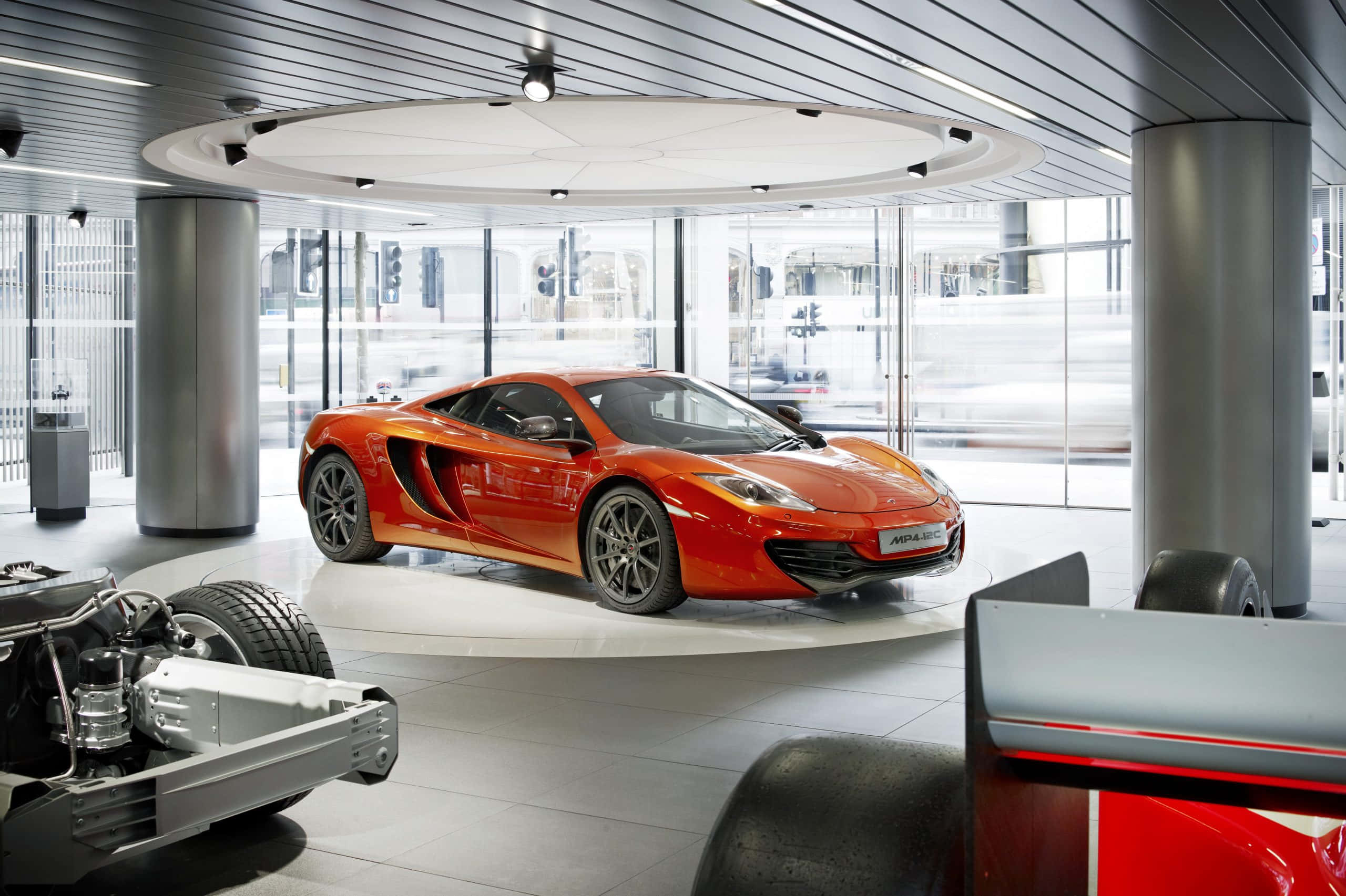 McLaren MP4-12C, vibrant orange, modern showroom lights, 2K Desktop Wallpaper