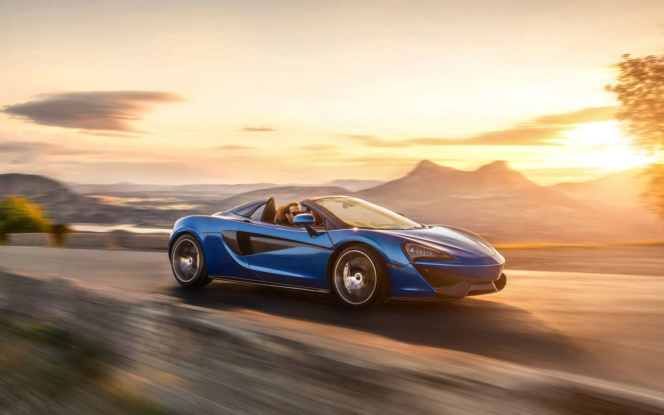 blue McLaren Spyder, winding mountain road, sunset, 2K Desktop Wallpaper