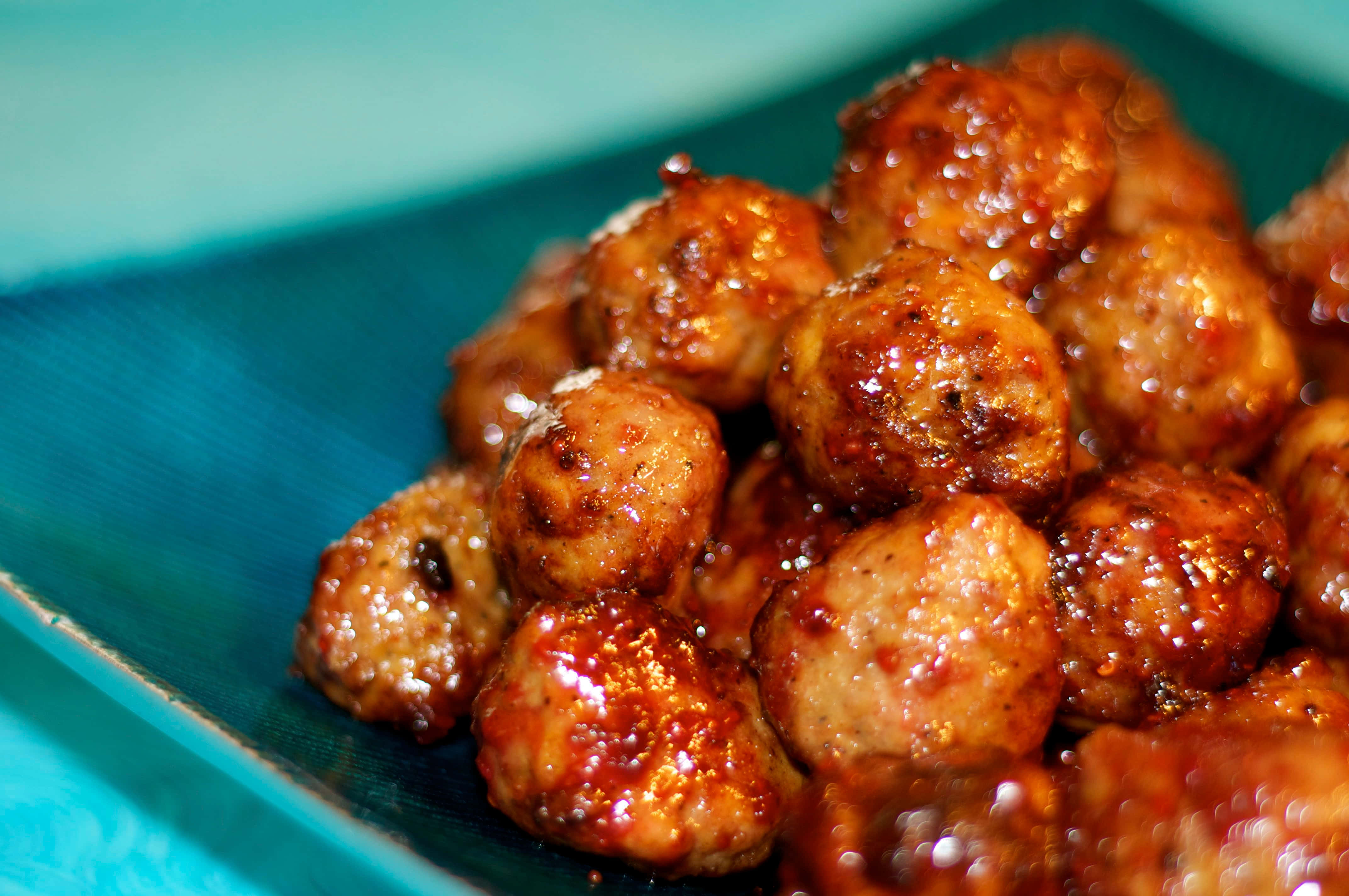 juicy glazed meatballs, vibrant teal plate, shallow depth of field, 4K Desktop Wallpaper