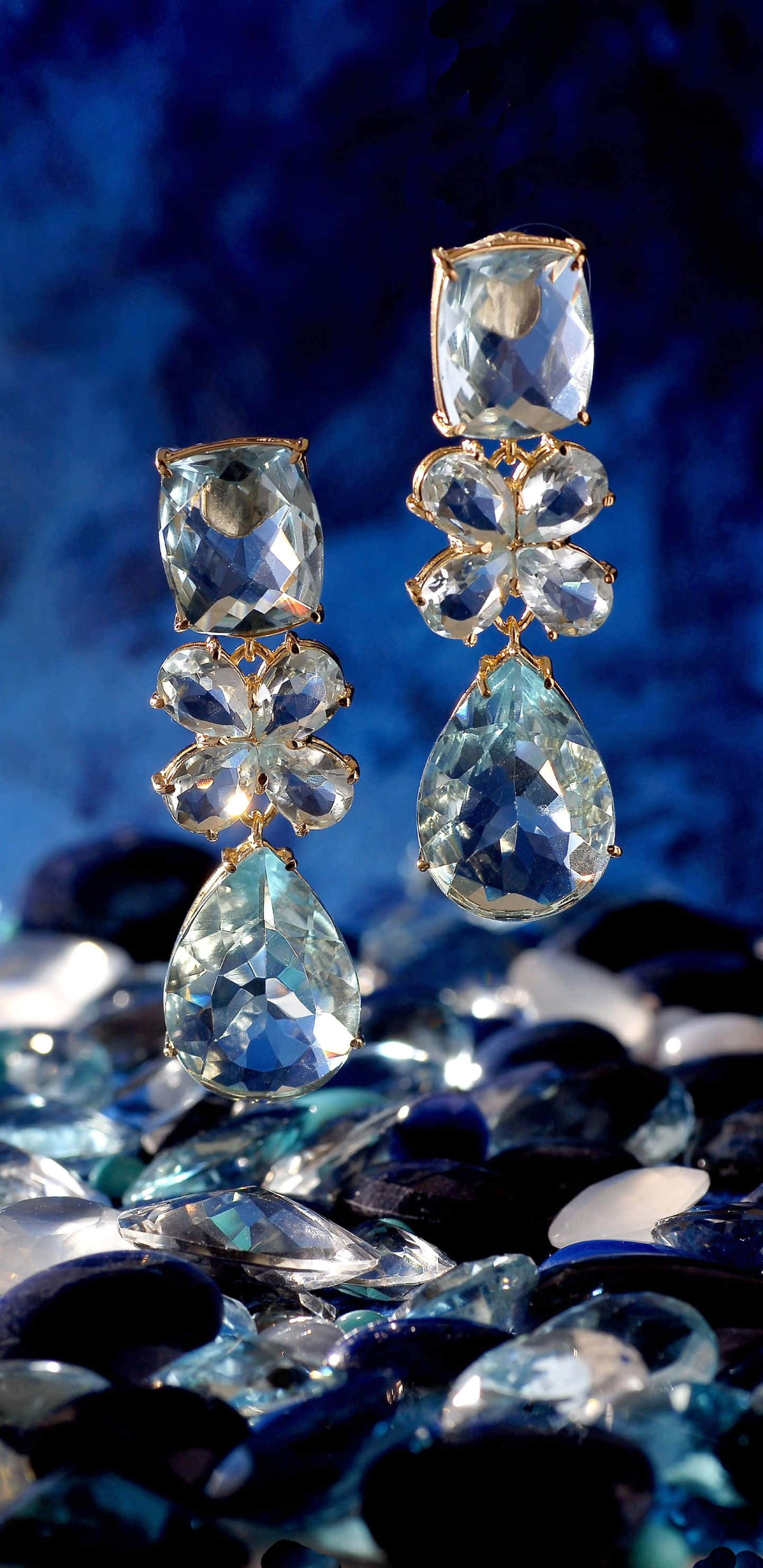 blue crystal drop earrings, deep blue textured backdrop, scattered gemstones, 2K Phone Wallpaper