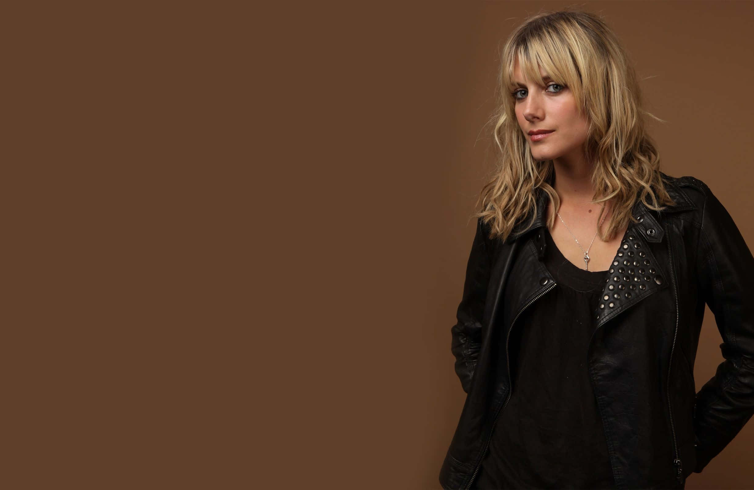 Mélanie Laurent, black studded leather jacket, solid brown studio backdrop, Full HD Desktop Wallpaper