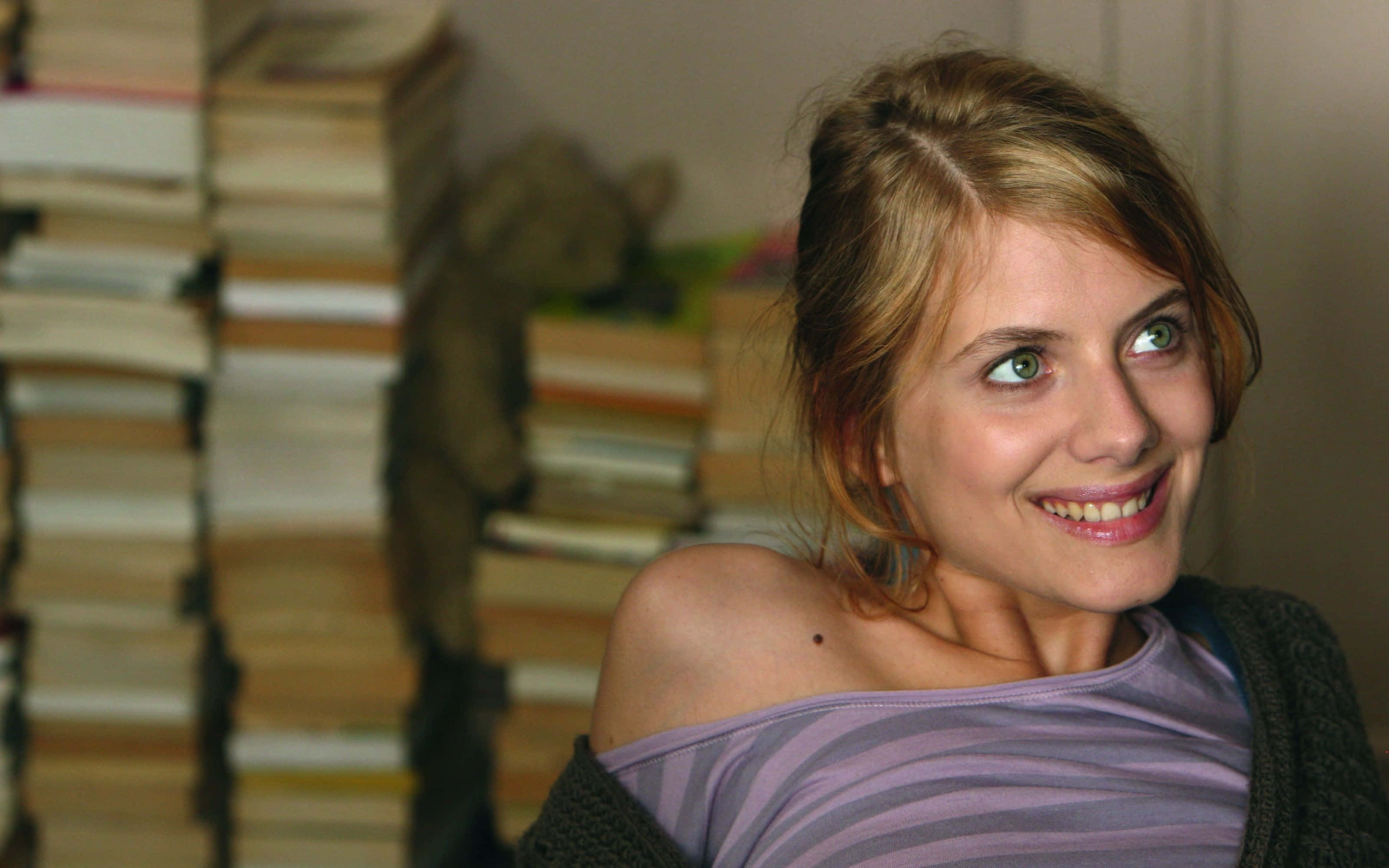 Mélanie Laurent, blonde hair, towering stacks of books, 2K Desktop Wallpaper
