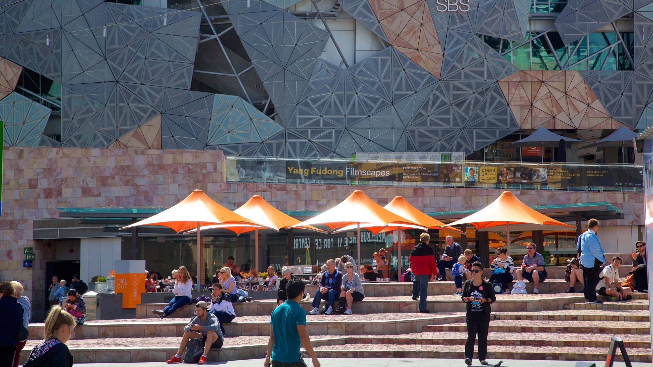 Melbourne Federation Square, bright orange umbrellas, stone steps, 2K Desktop Wallpaper