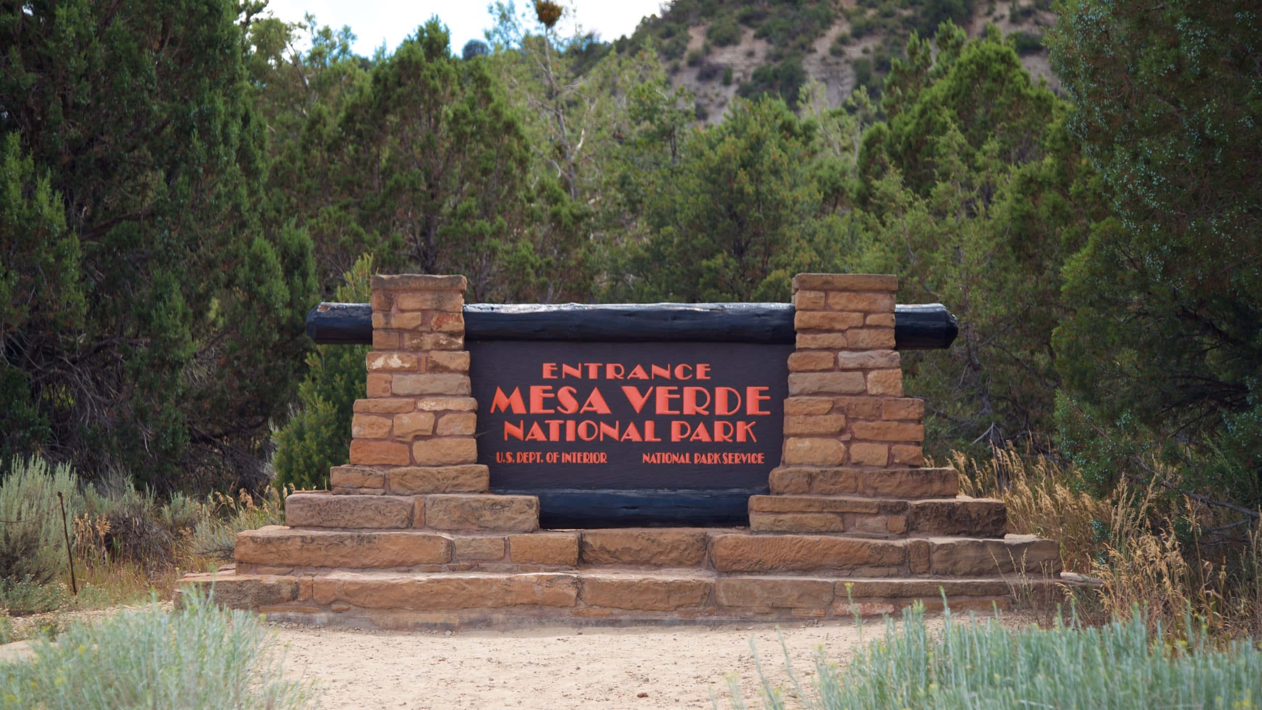Mesa Verde National Park, entrance sign, dense evergreen trees, 2K Desktop Wallpaper