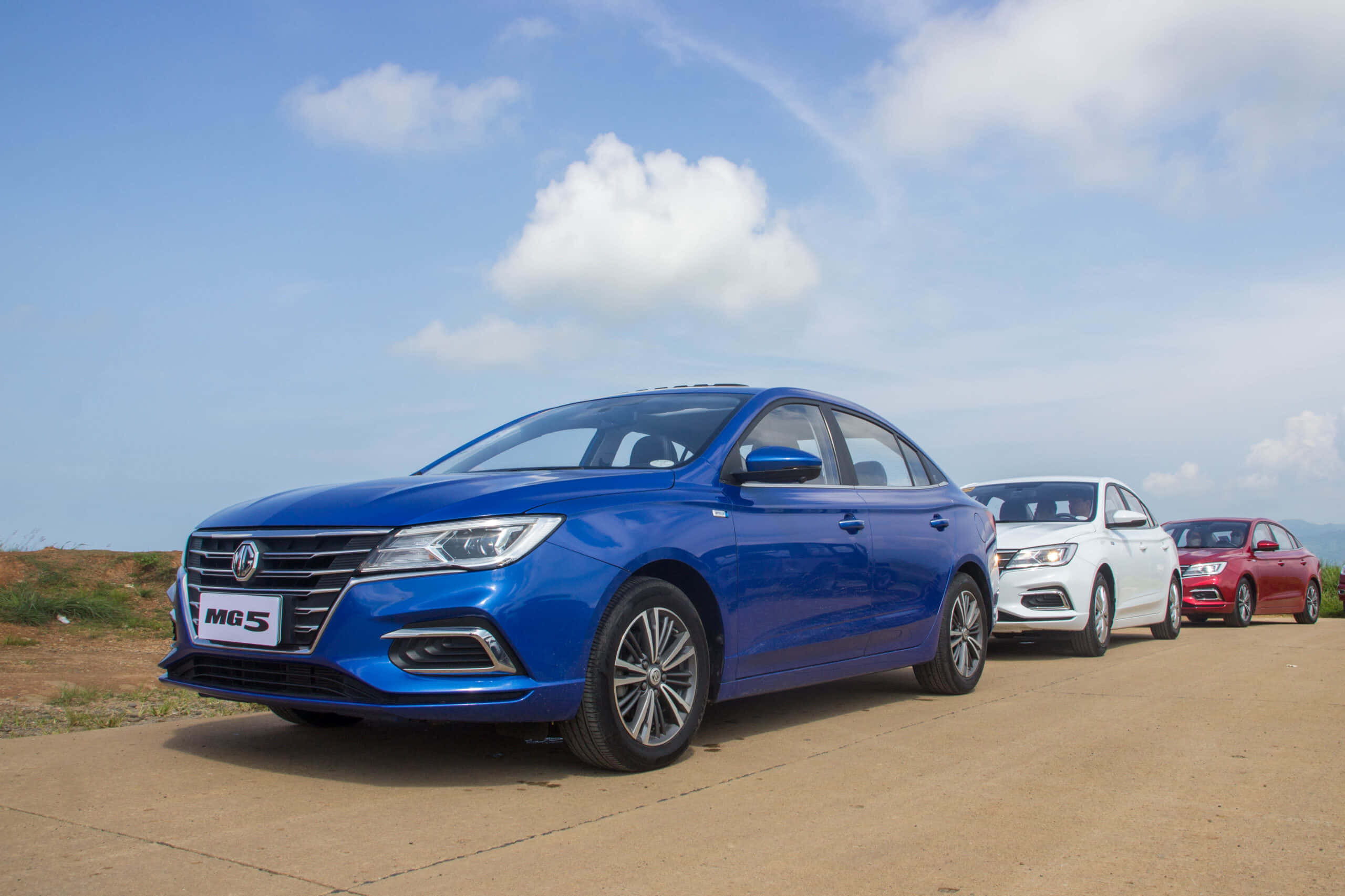 blue M G5 Sedan, paved road, bright blue sky, 2K Desktop Wallpaper