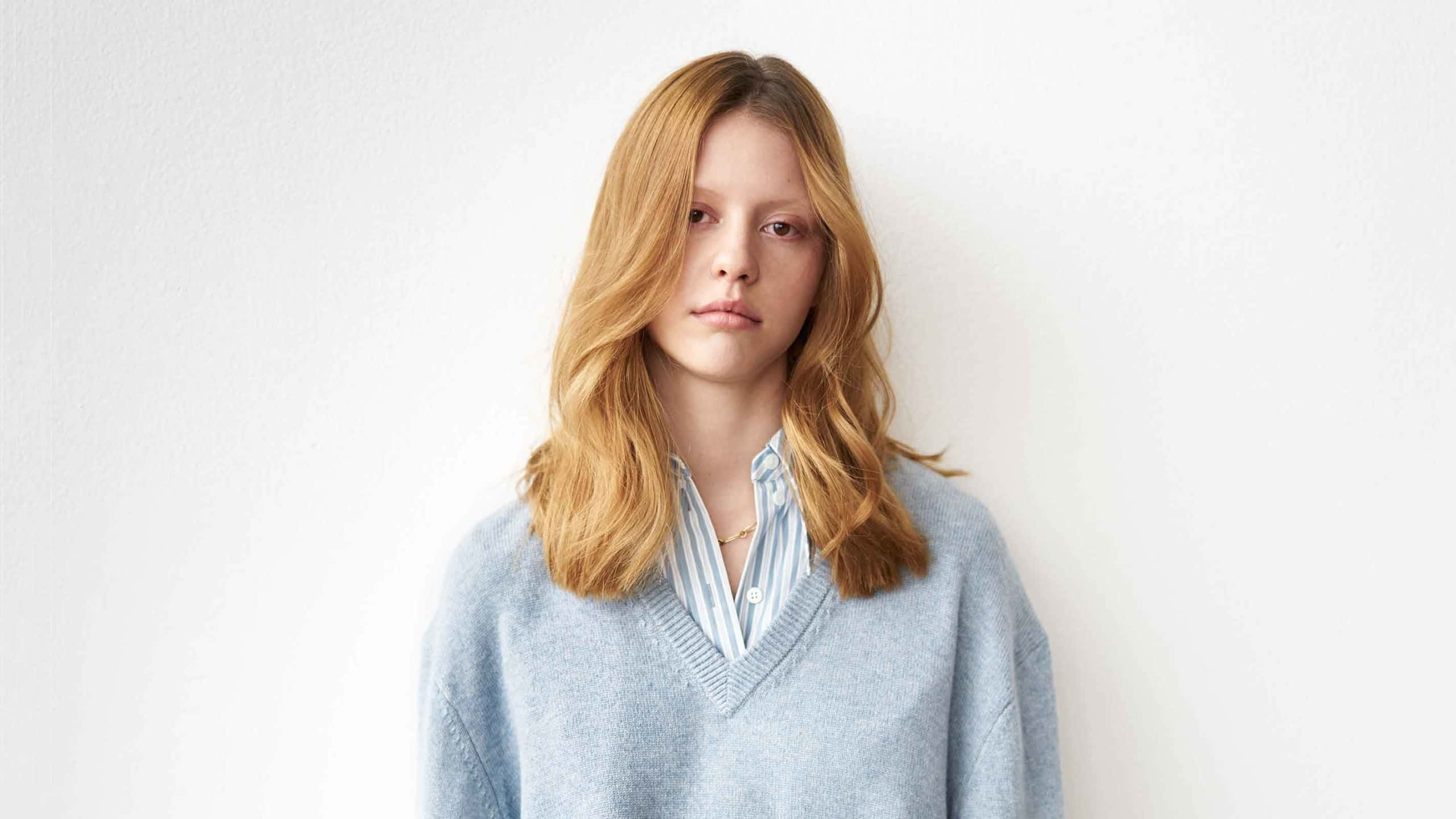 Mia Goth, wavy blonde hair, light blue sweater, 2K Desktop Wallpaper