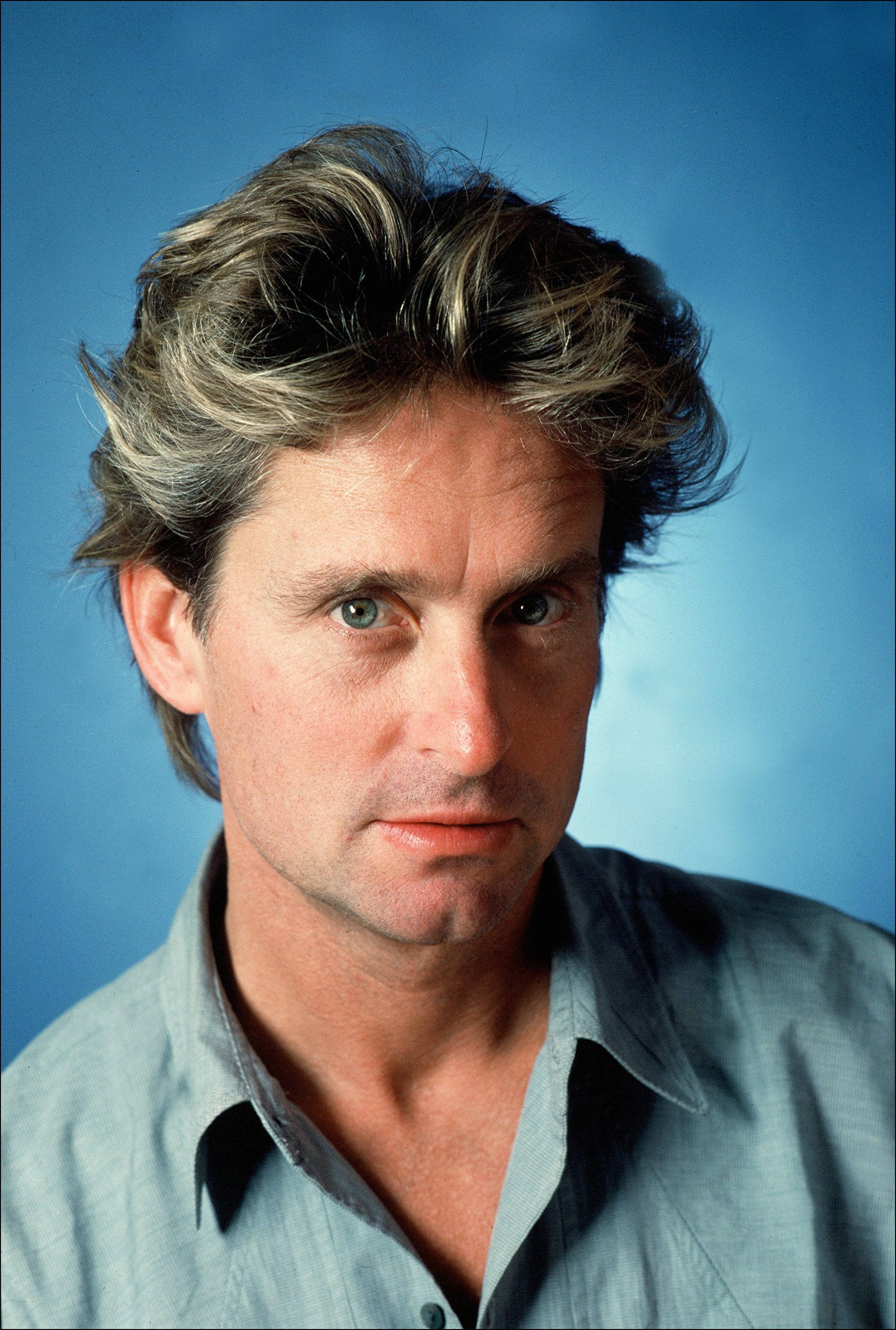 Michael Douglas, tousled blonde hair, intense green eyes, 2K Phone Wallpaper