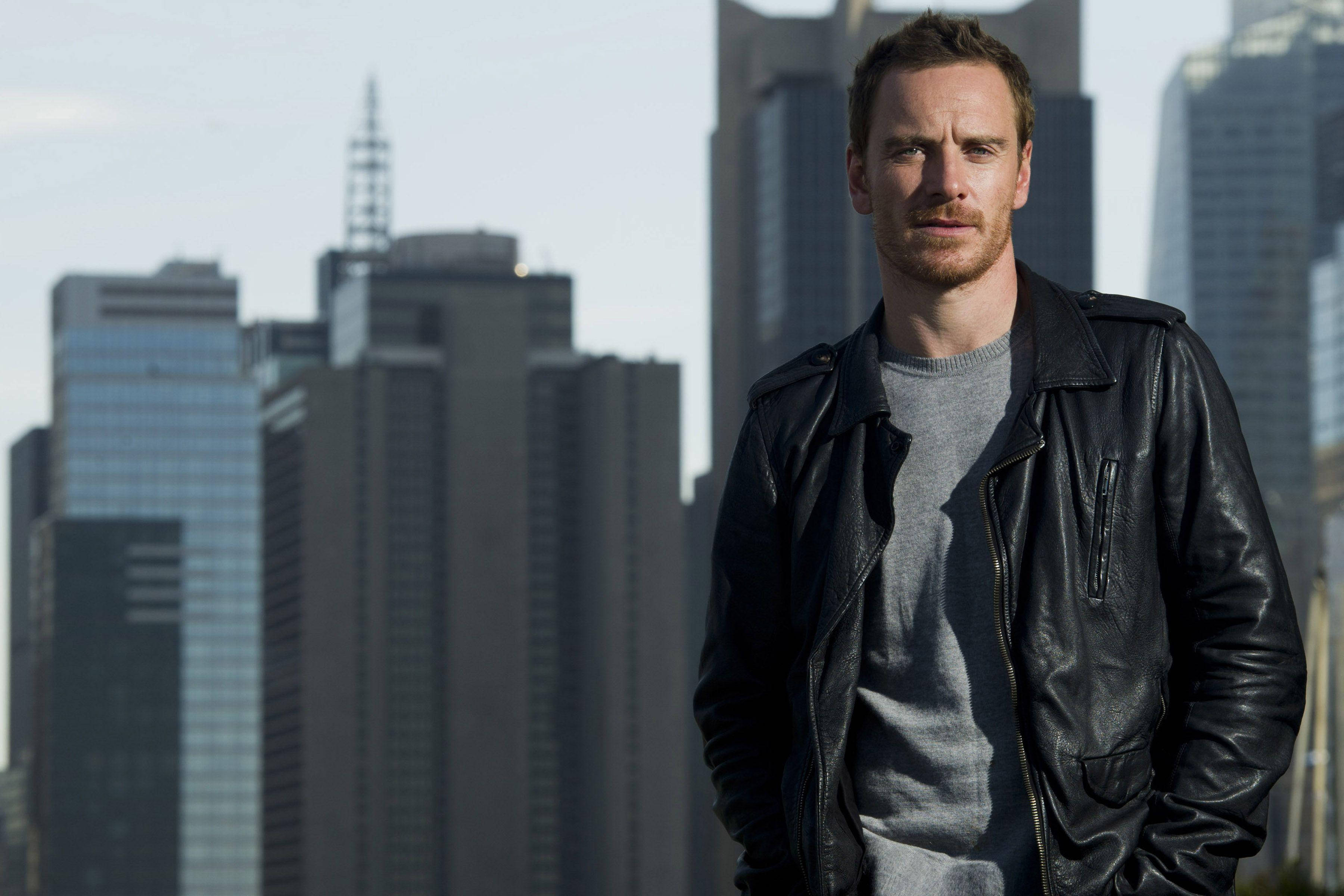 Michael Fassbender, black leather jacket, city skyscrapers, 2K Desktop Wallpaper