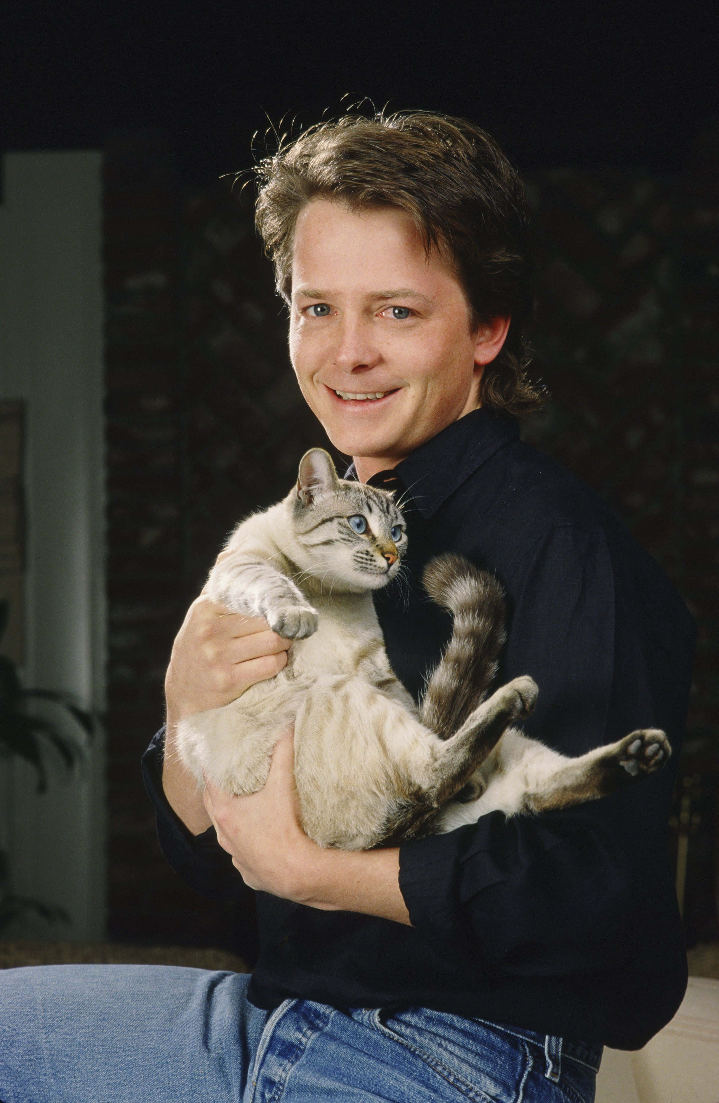 Michael J Fox, dark shirt, light gray tabby cat, 2K Phone Wallpaper