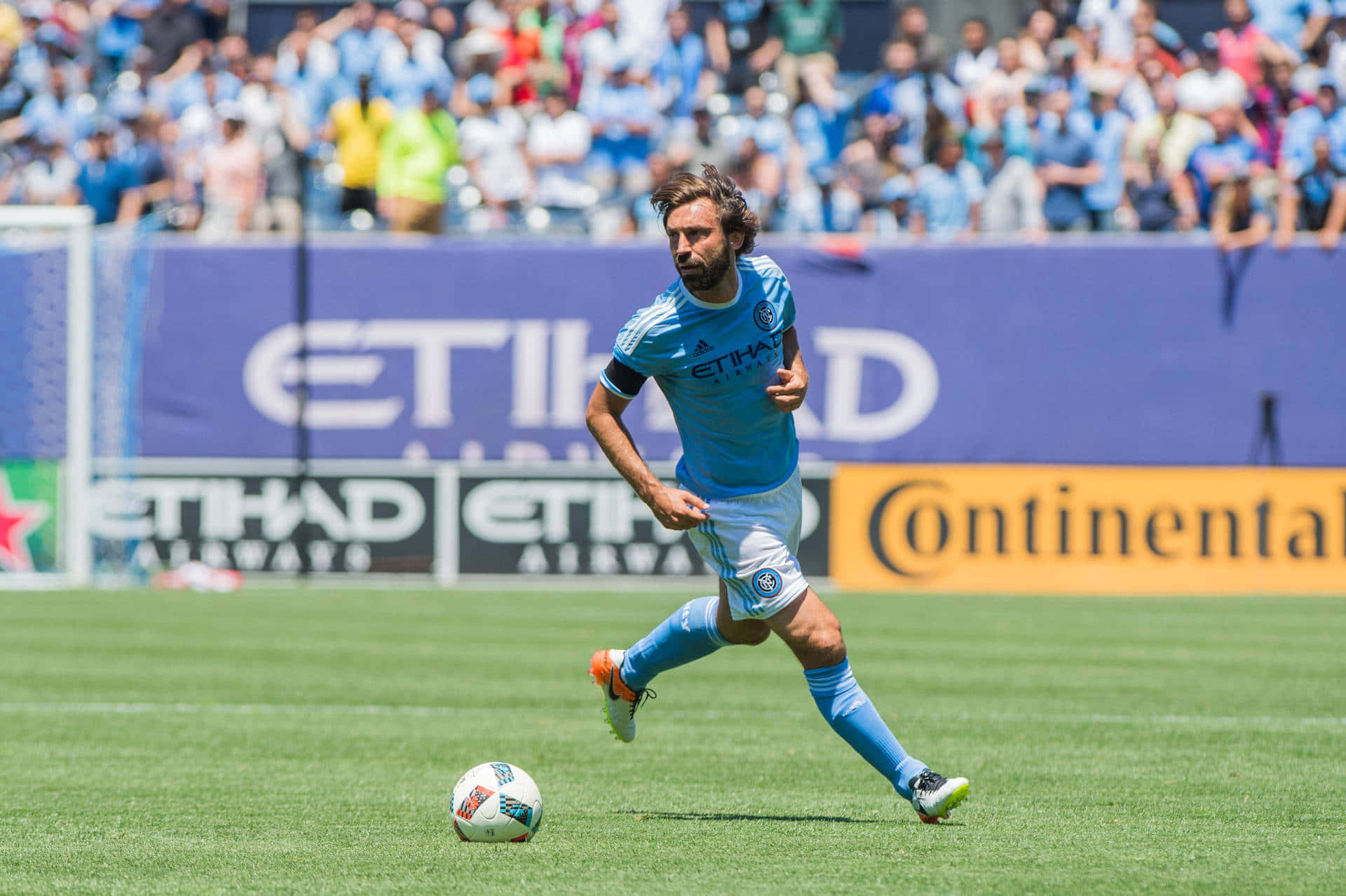 Midfielder, light blue uniform, sunlit green field, Full HD Desktop Wallpaper