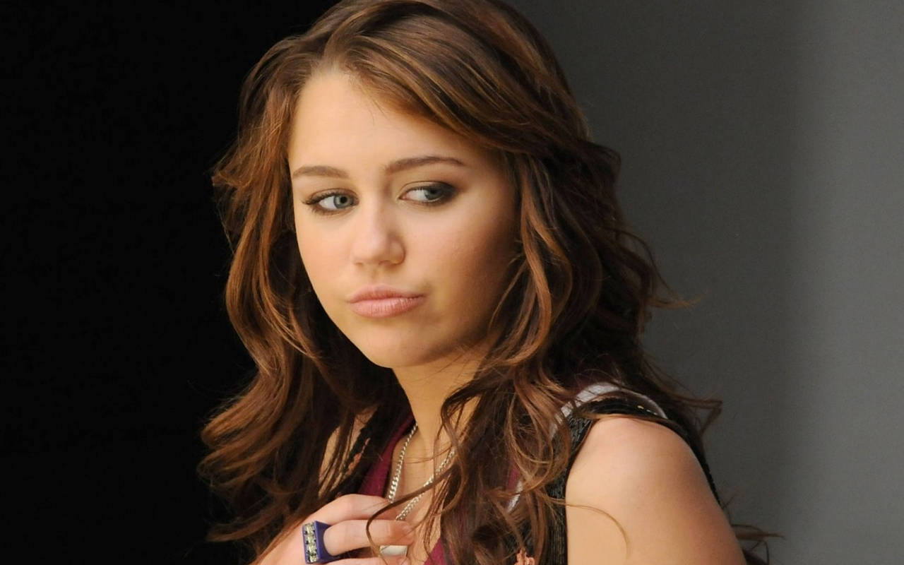 Miley Cyrus, wavy brown hair, serious expression, HD Desktop Wallpaper