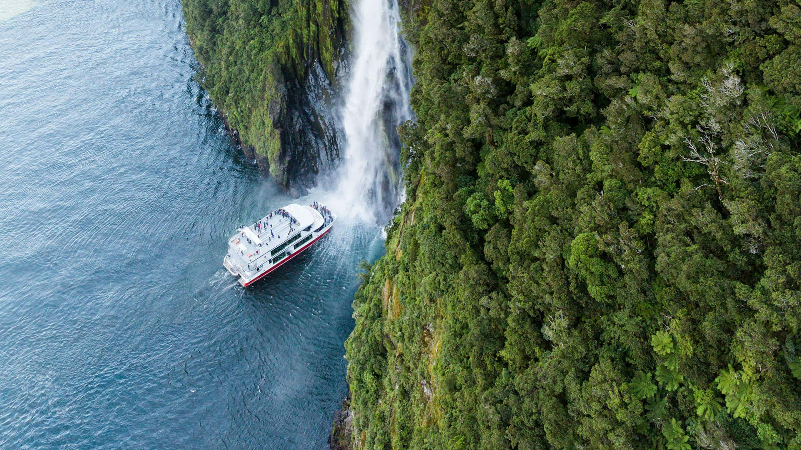 Milford Sound, white tour boat, towering waterfall, 2K Desktop Wallpaper