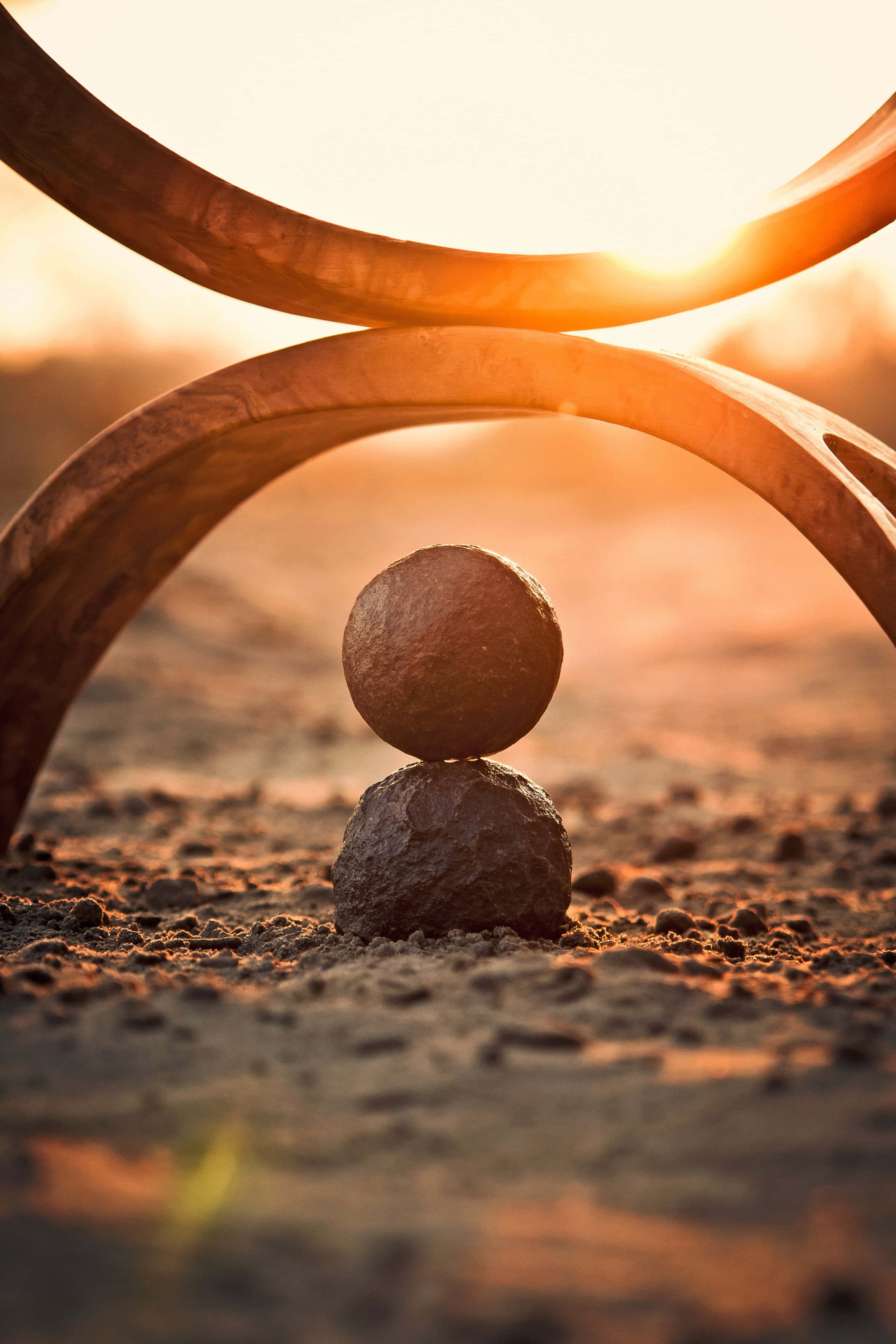 rusted metal sculpture, curved arches, balanced stone sphere, 4K Phone Wallpaper