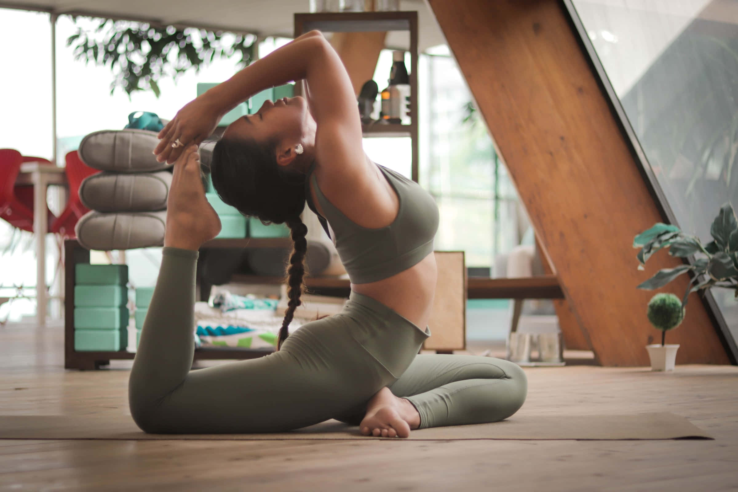 olive green yoga attire, deep seated twist pose, wooden floor, Full HD Desktop Wallpaper