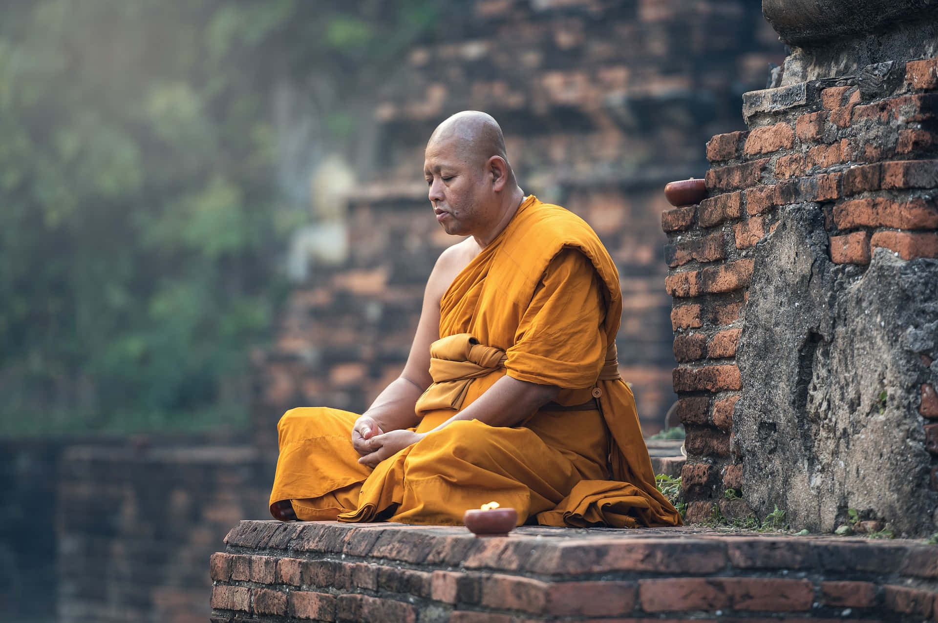 sitting monk, golden robes, ancient weathered brick ruins, Full HD Desktop Wallpaper
