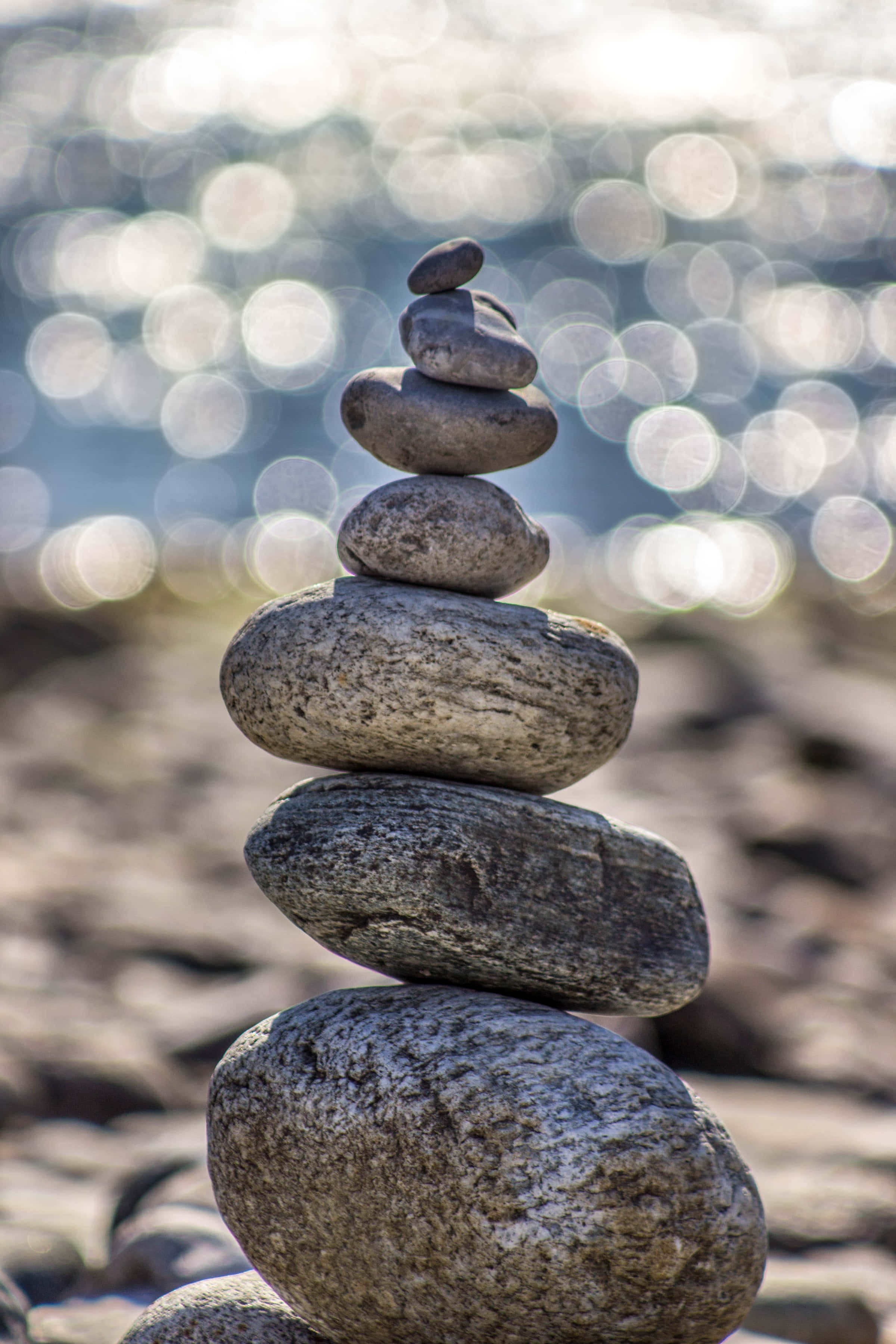 rocks of mindfulness, smooth river stones, sparkling sunlit water, 2K Phone Wallpaper