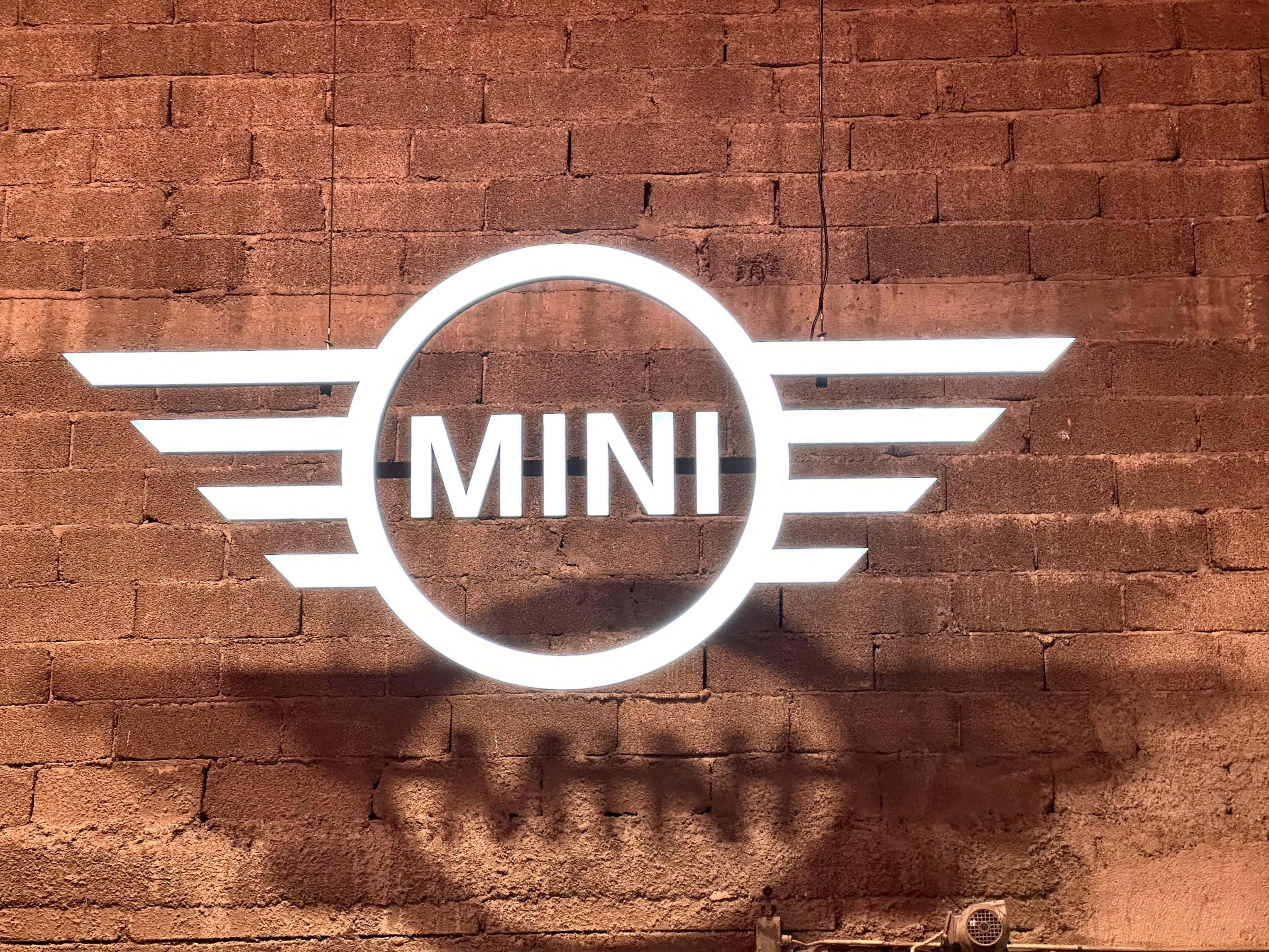 MINI logo, winged emblem, textured red brick wall, 2K Desktop Wallpaper
