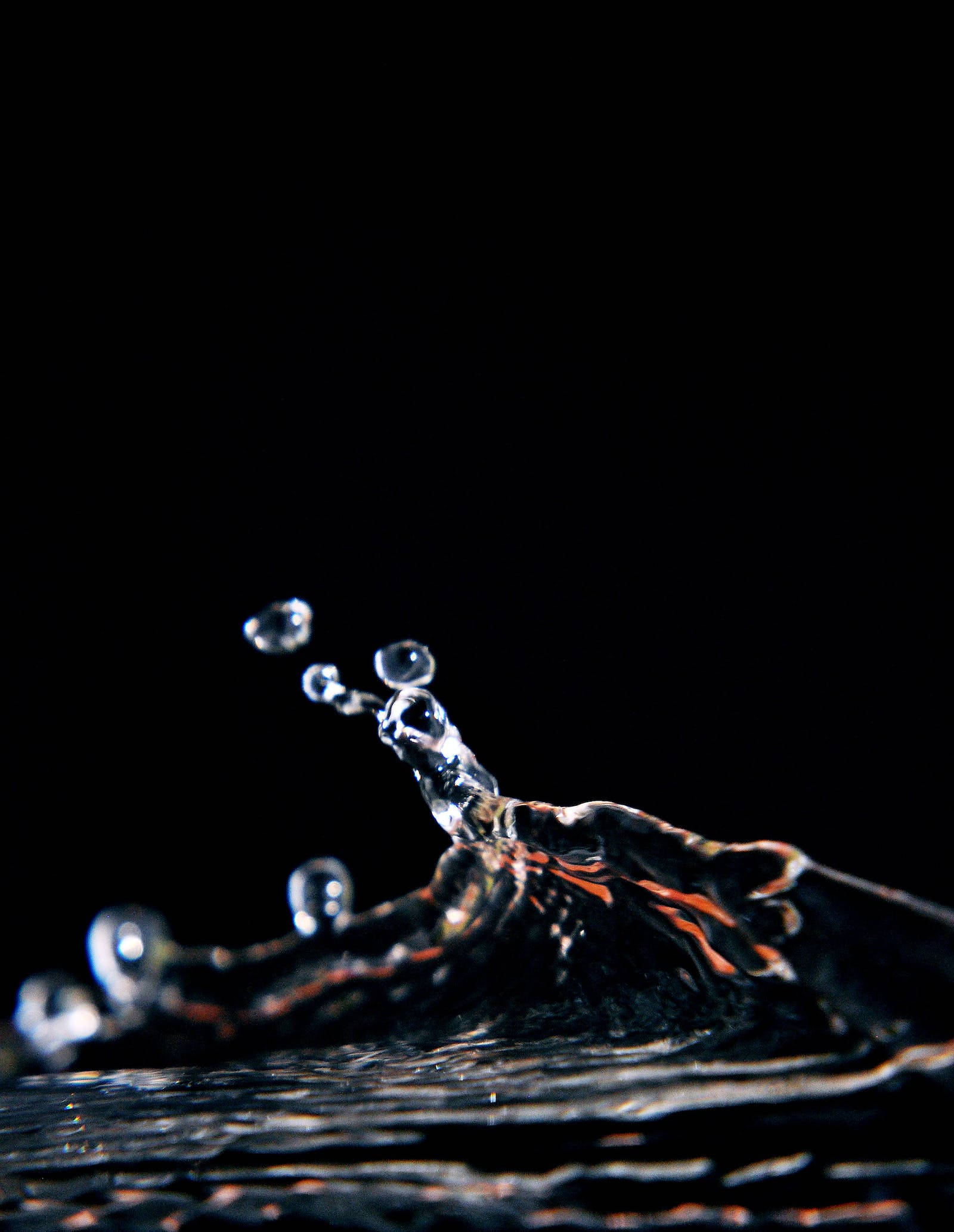 water splash, pure black background, glowing orange reflections, Full HD Phone Wallpaper