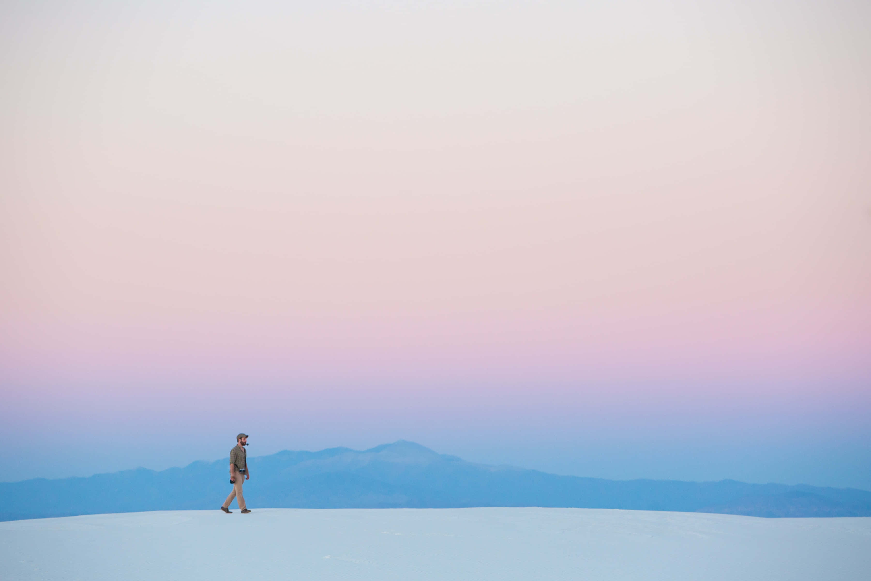 white desert, soft pink and blue twilight sky, distant mountains, 2K Desktop Wallpaper