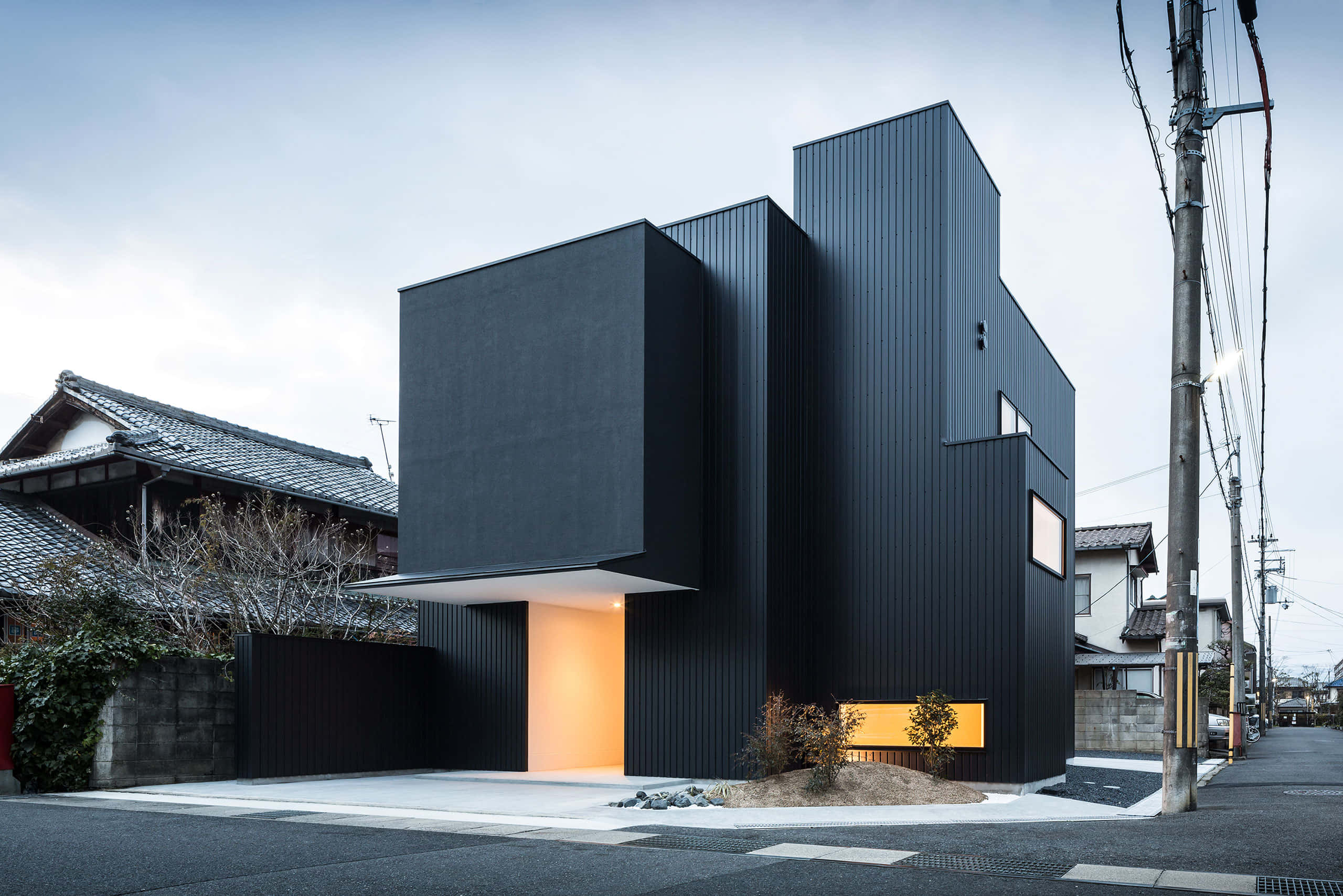 minimalist architecture, modern black geometric house, glowing orange entrance, 2K Desktop Wallpaper