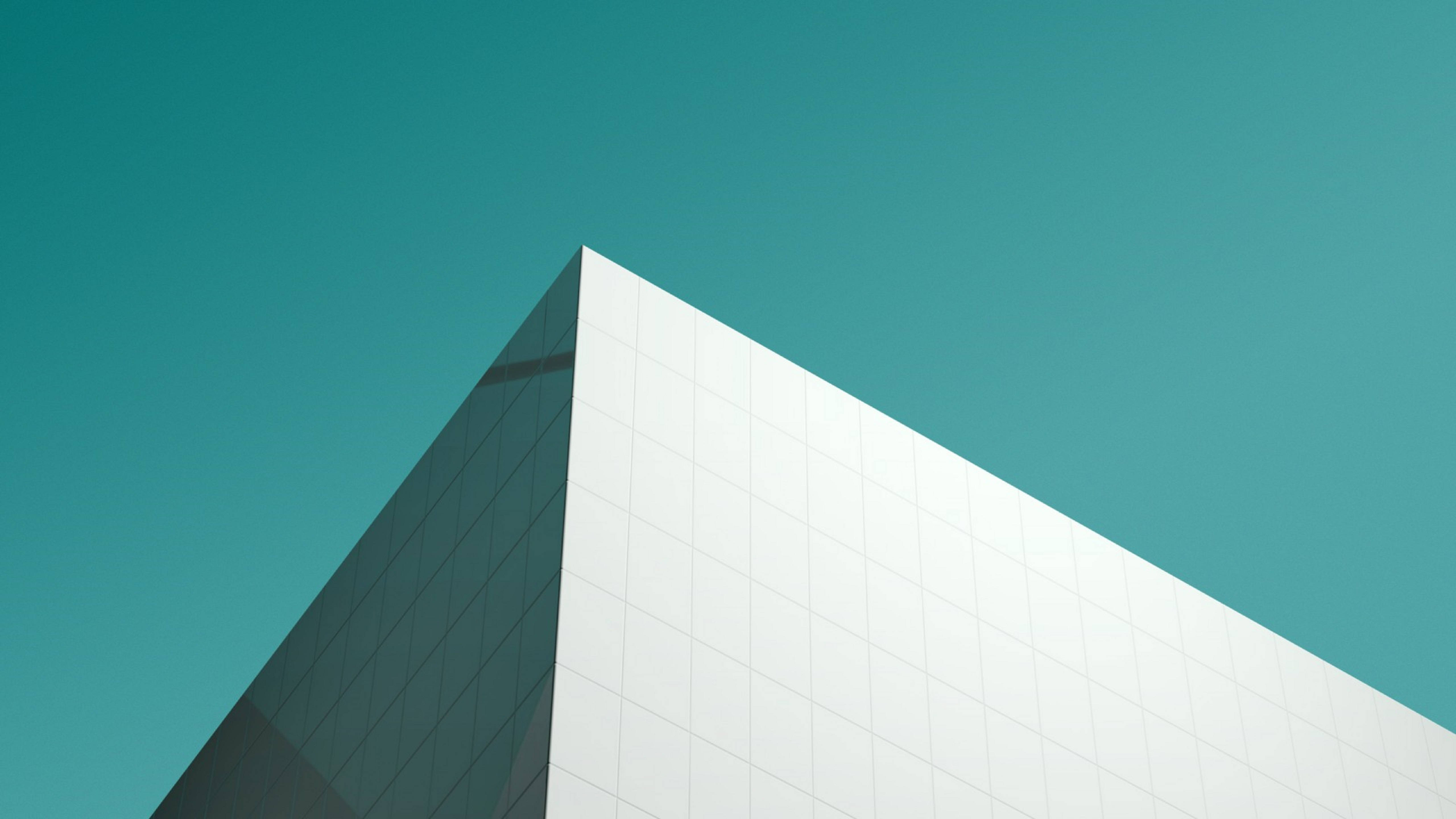modern glass and white panel building, sharp geometric corner, clear teal sky, 5K Desktop Wallpaper