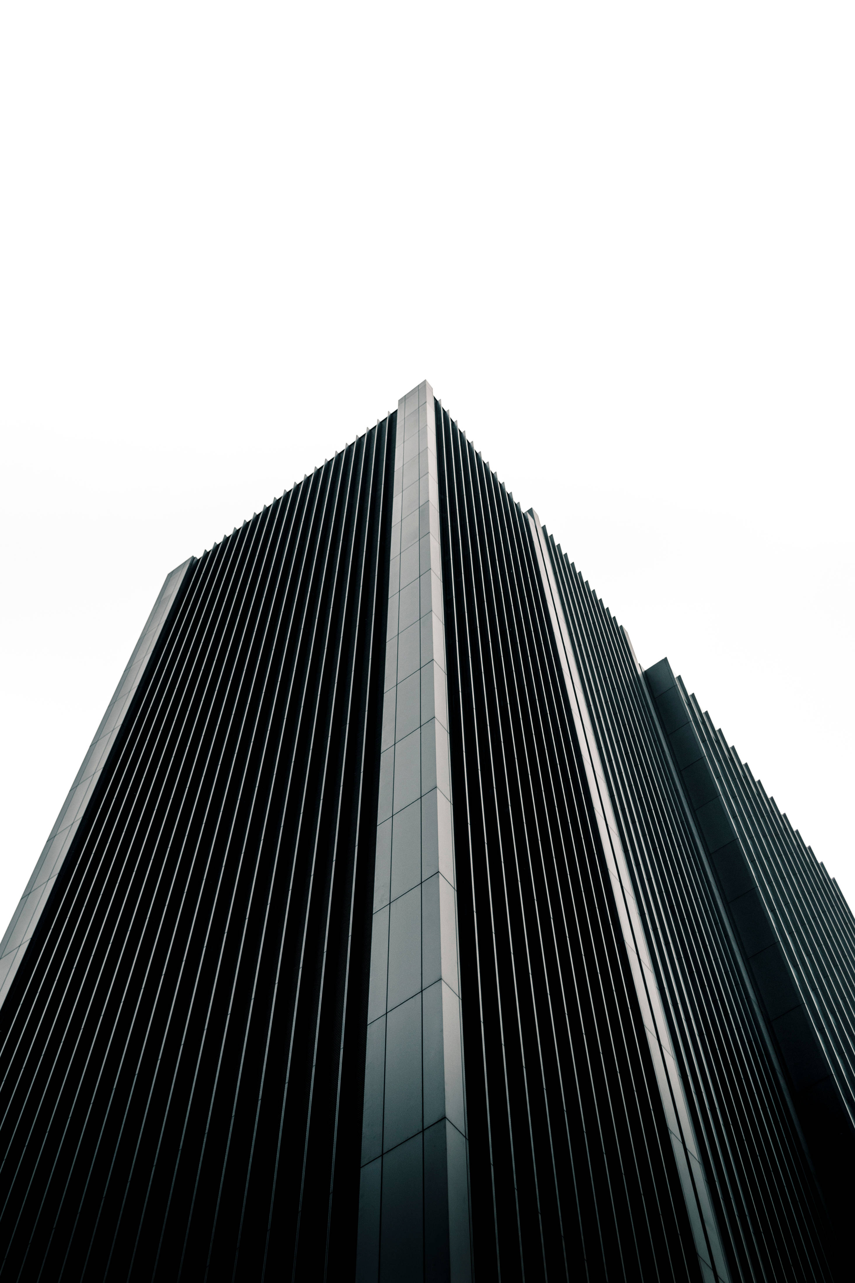 minimalist futuristic city building, sleek modern skyscraper, vertical glass panels, 4K Phone Wallpaper