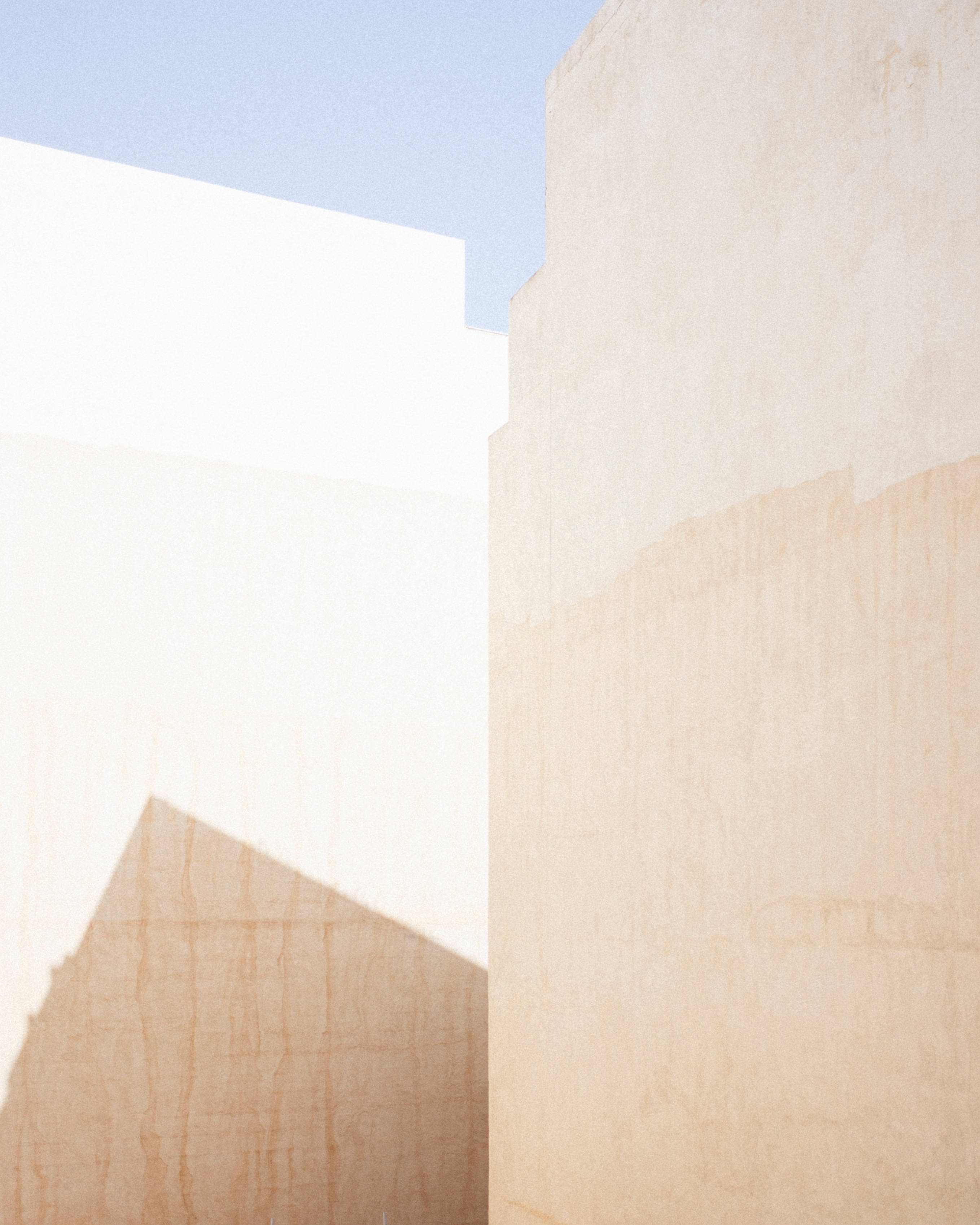 Minimalist Wall Malta, warm beige walls, pale blue sky, 2K Phone Wallpaper