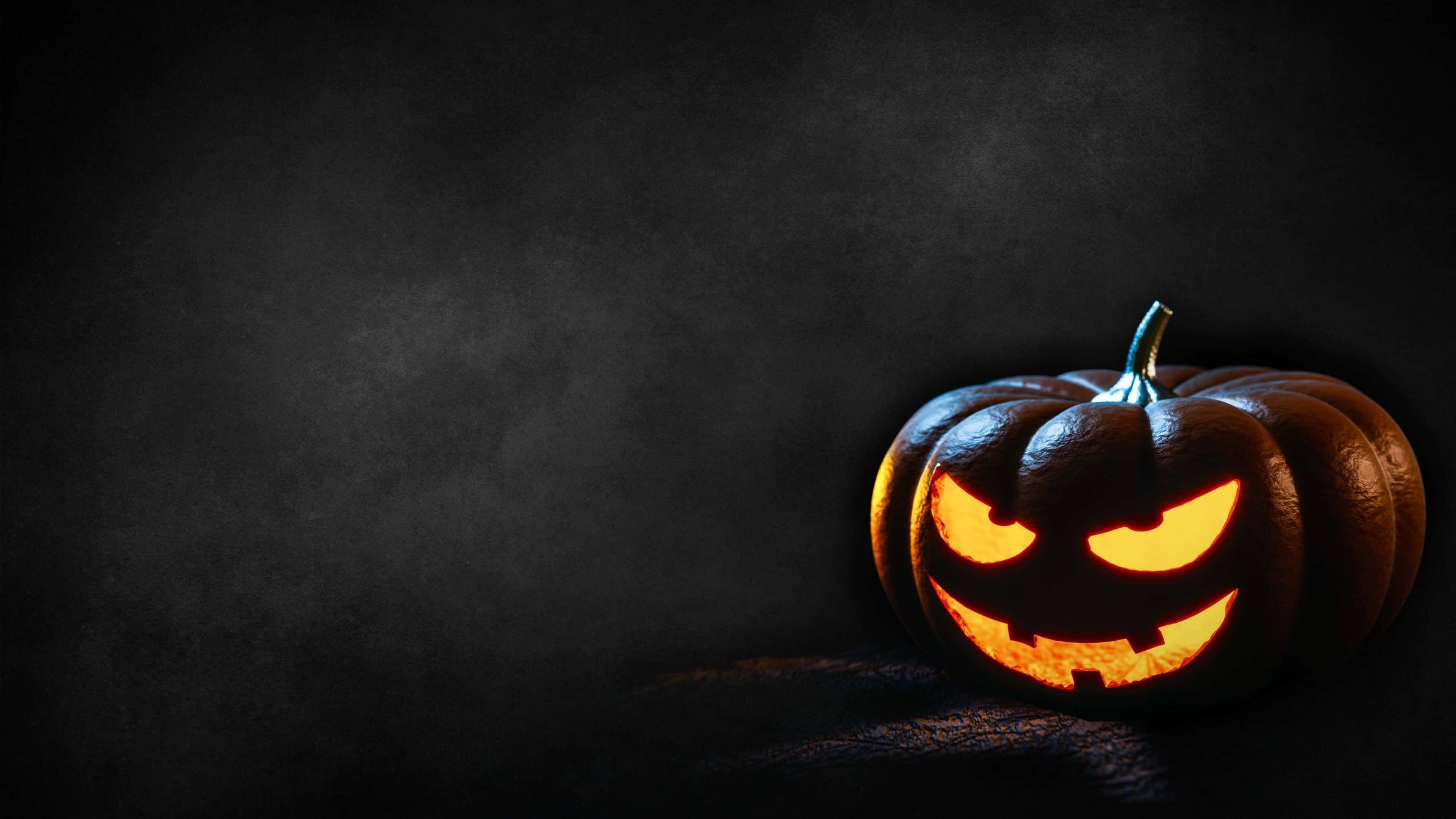 jack-o'-lantern, menacing grin, eerie orange light, 2K Desktop Wallpaper