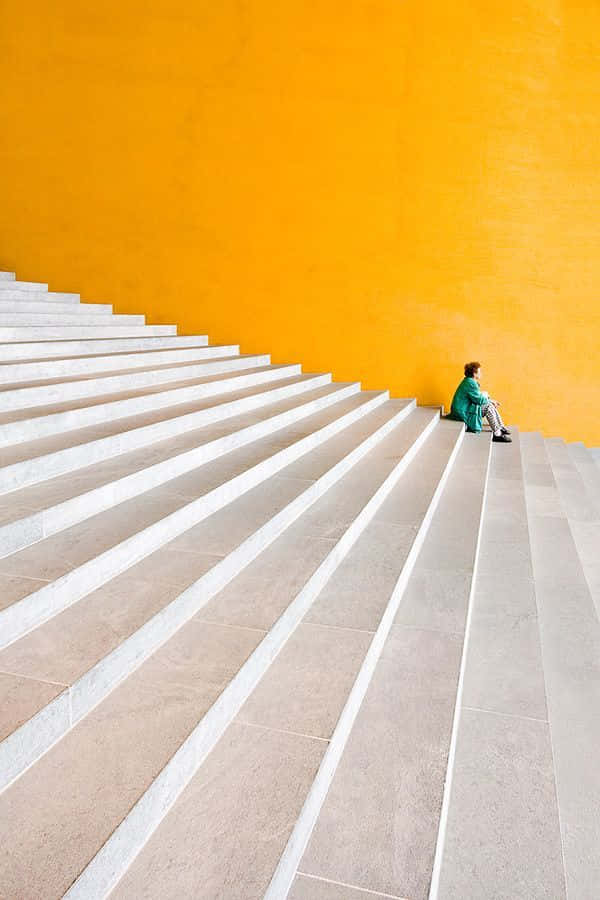 green outfit, wide staircase, vibrant orange wall, SD Phone Wallpaper