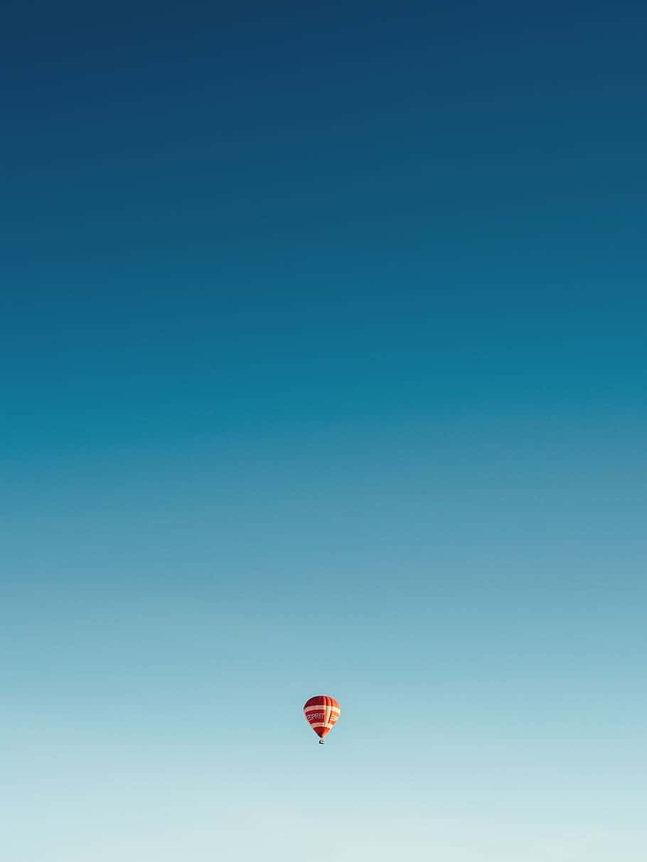 red and white hot air balloon, vast gradient blue sky, solitary balloon journey, SD Phone Wallpaper