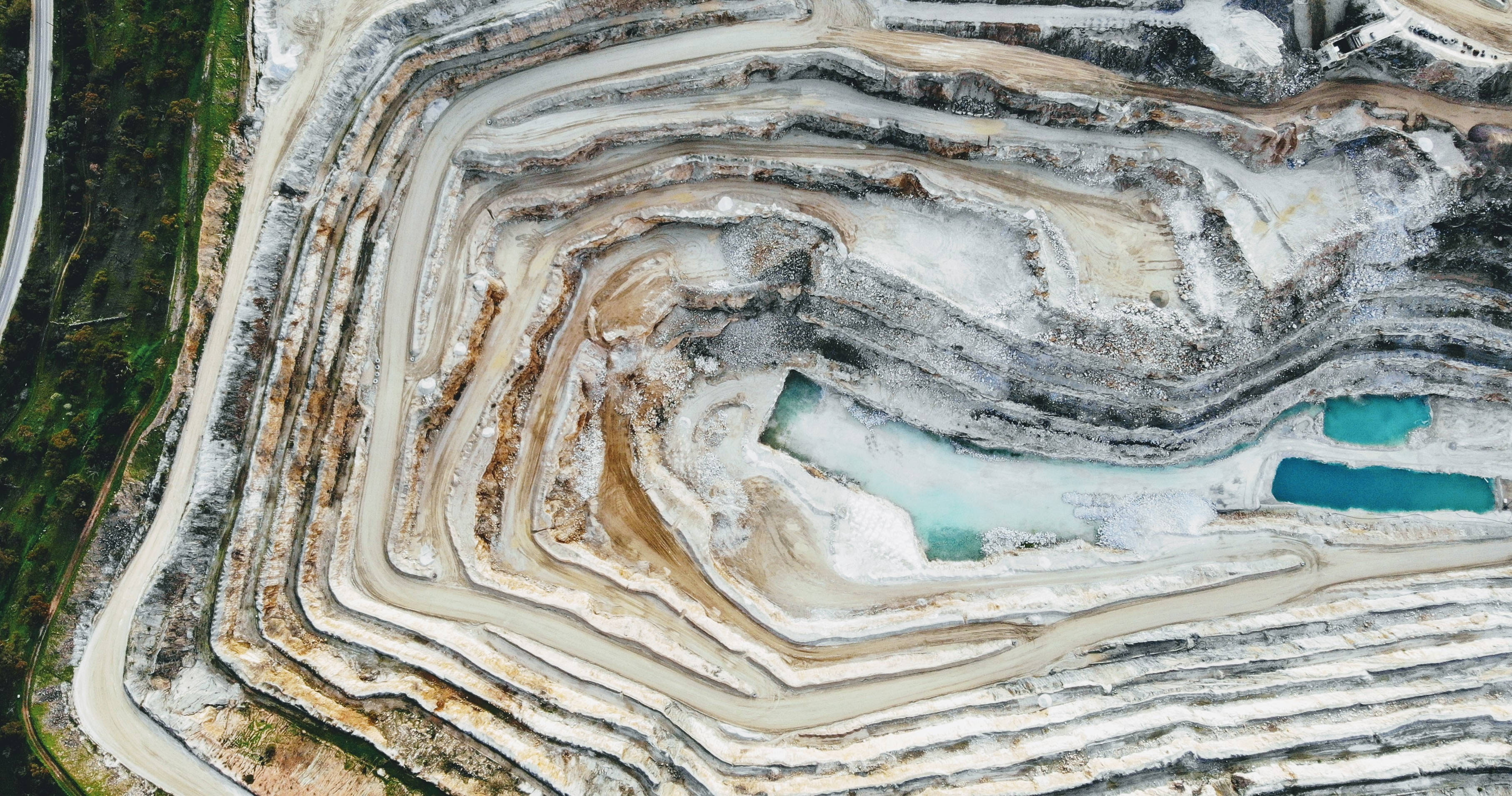 open-pit mine, terraced earth layers, turquoise water pools, 2K Desktop Wallpaper