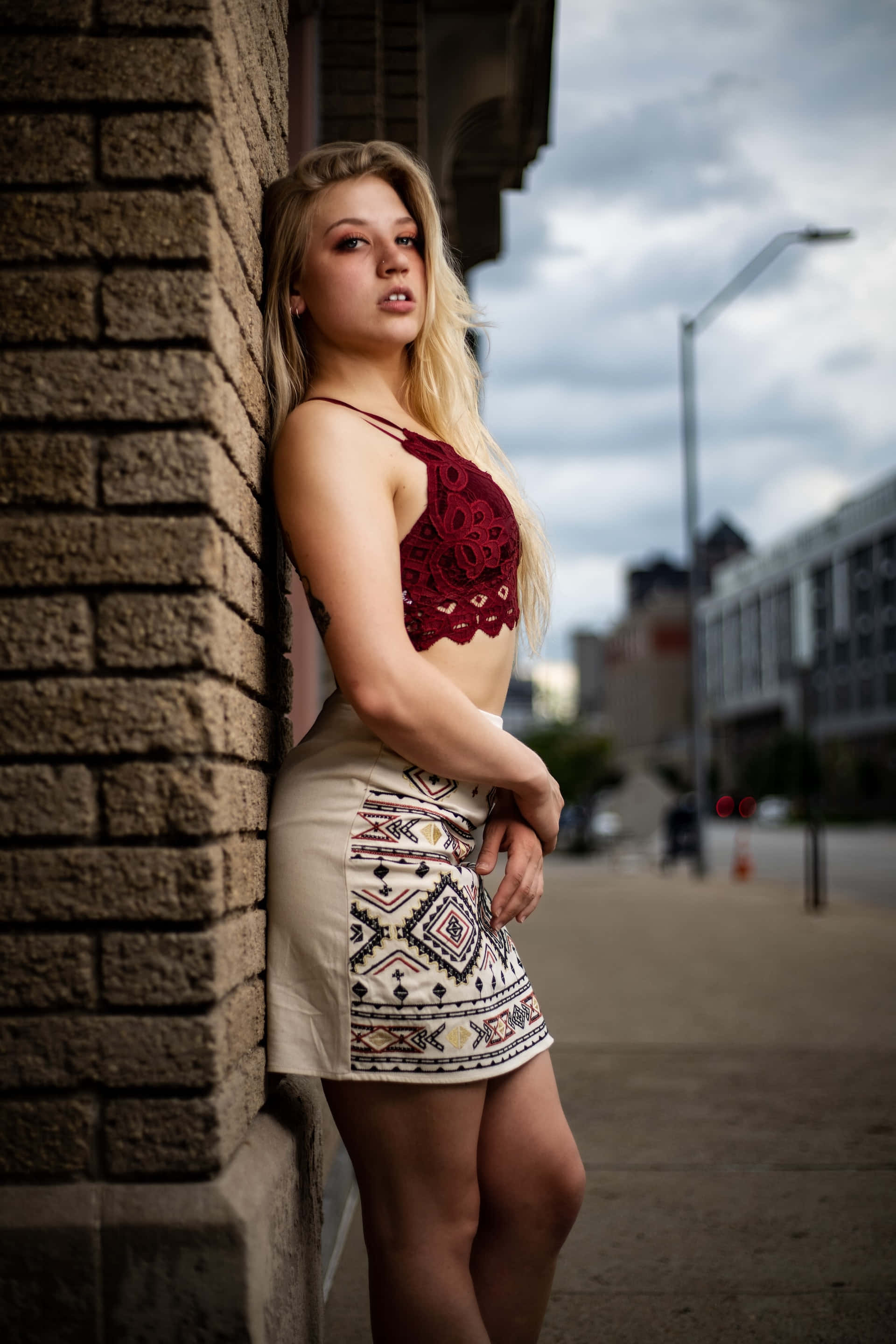 light brown miniskirt, blonde hair, brick wall, 2K Phone Wallpaper